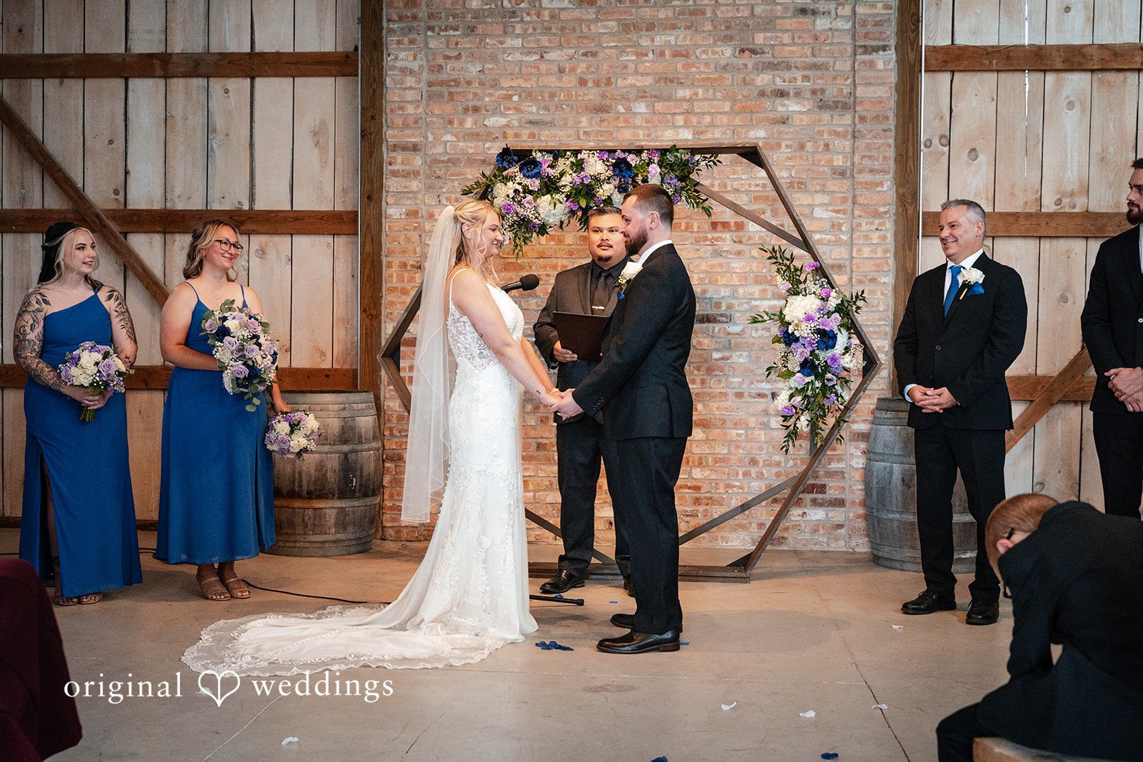 Wide shot of a ceremony taking place in front of a wooden arch.