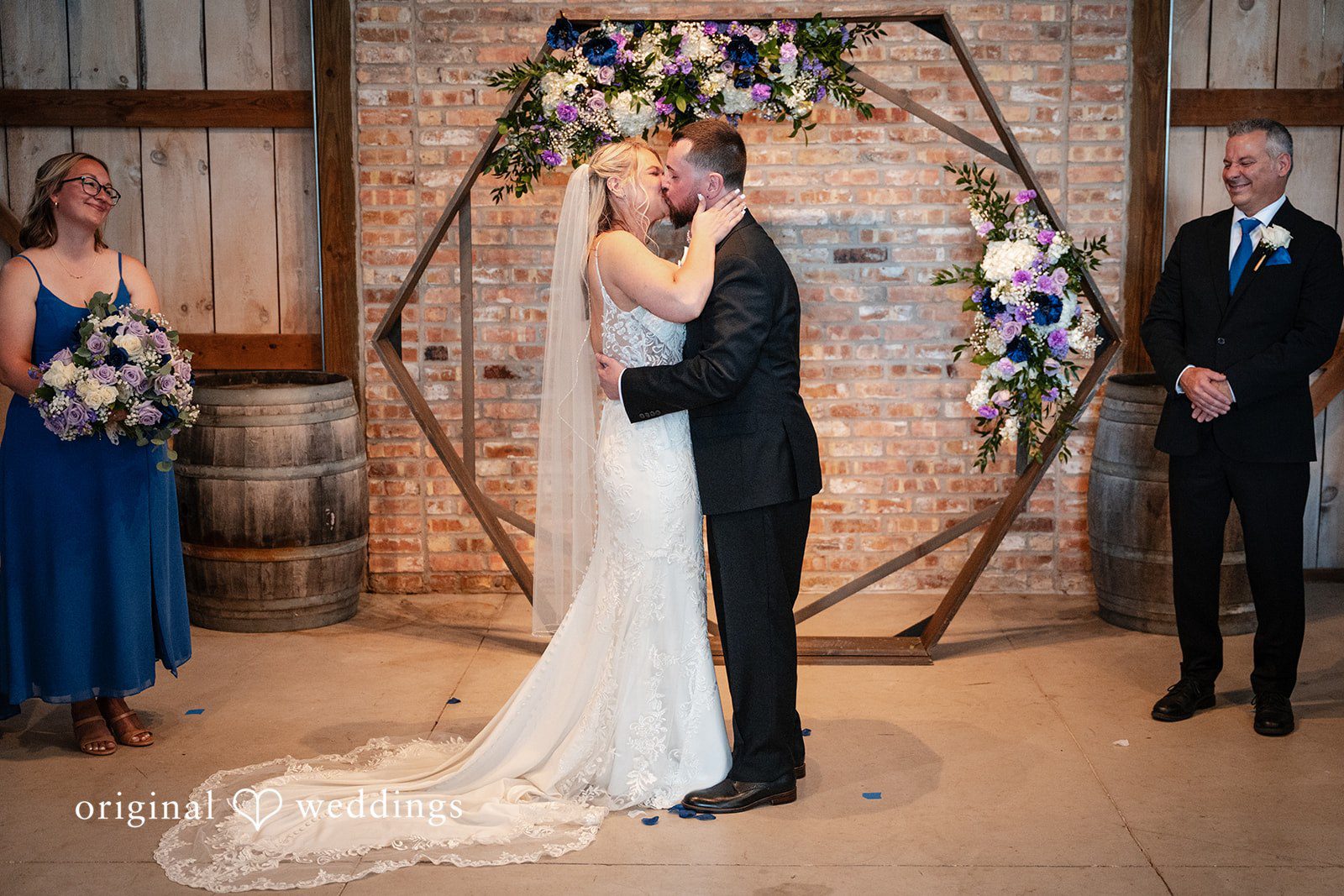 A bride and groom kissing at the altar.