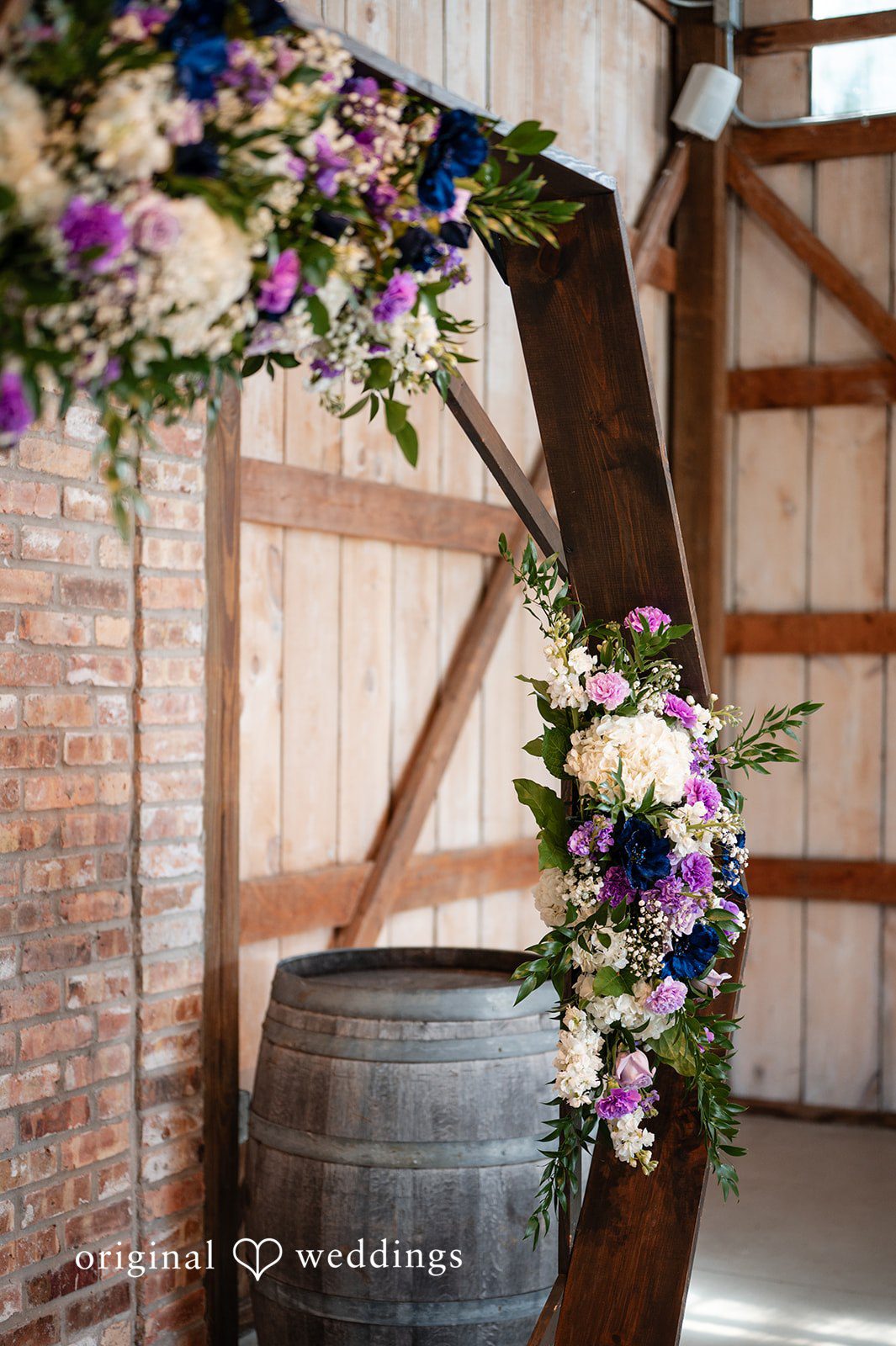 A wooden wedding arch decorated with vibrant flowers and greenery.