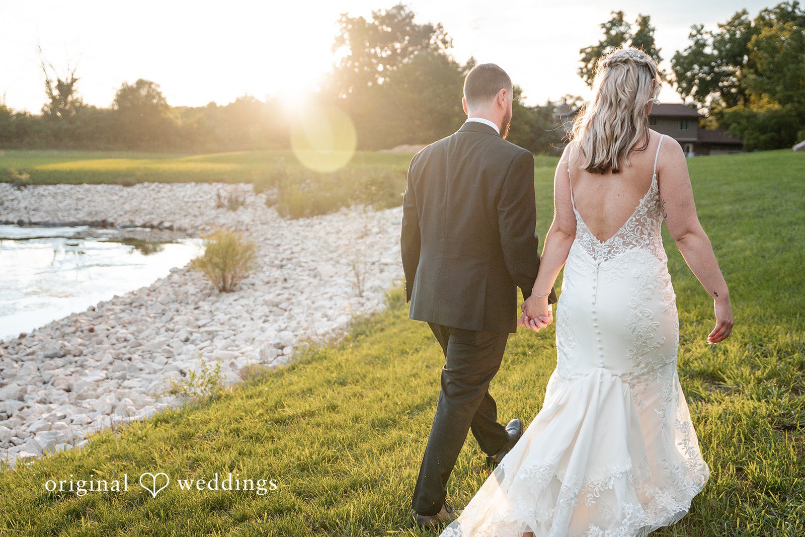 A bride and groom walking together down a gravel path.