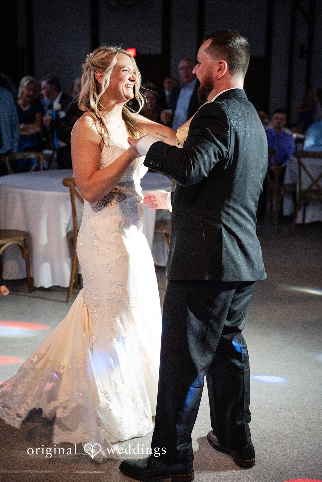 A bride and groom holding hands during their first dance at the reception.