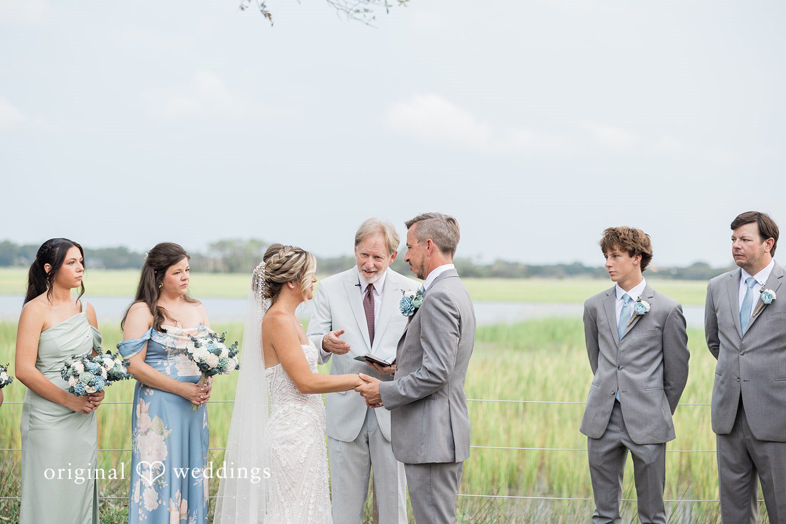Jennifer + Zac A wedding party standing together during a ceremony with the bride, groom, and bridesmaids.