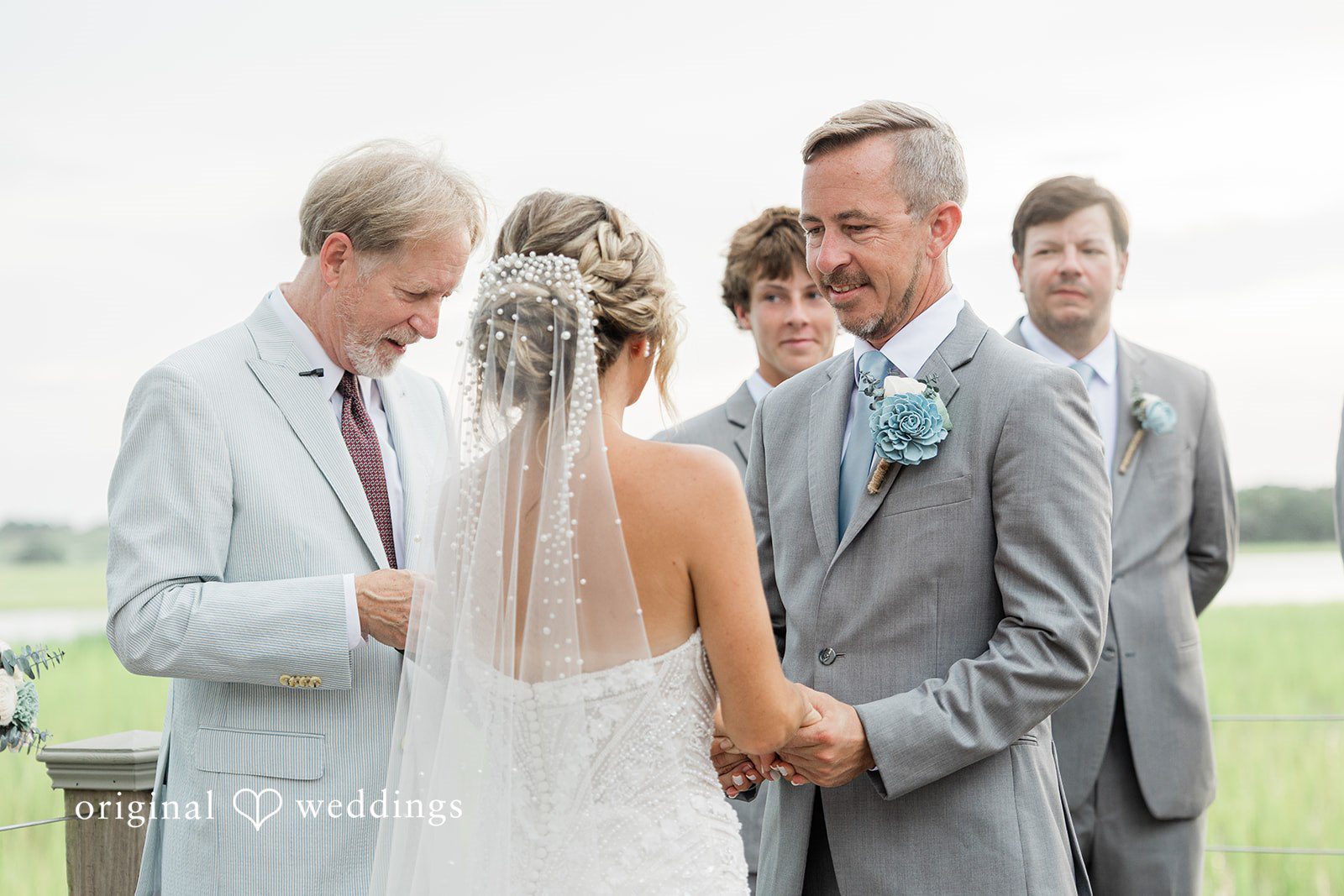 Jennifer + Zac A bride and groom standing at the altar with their wedding party during a ceremony.