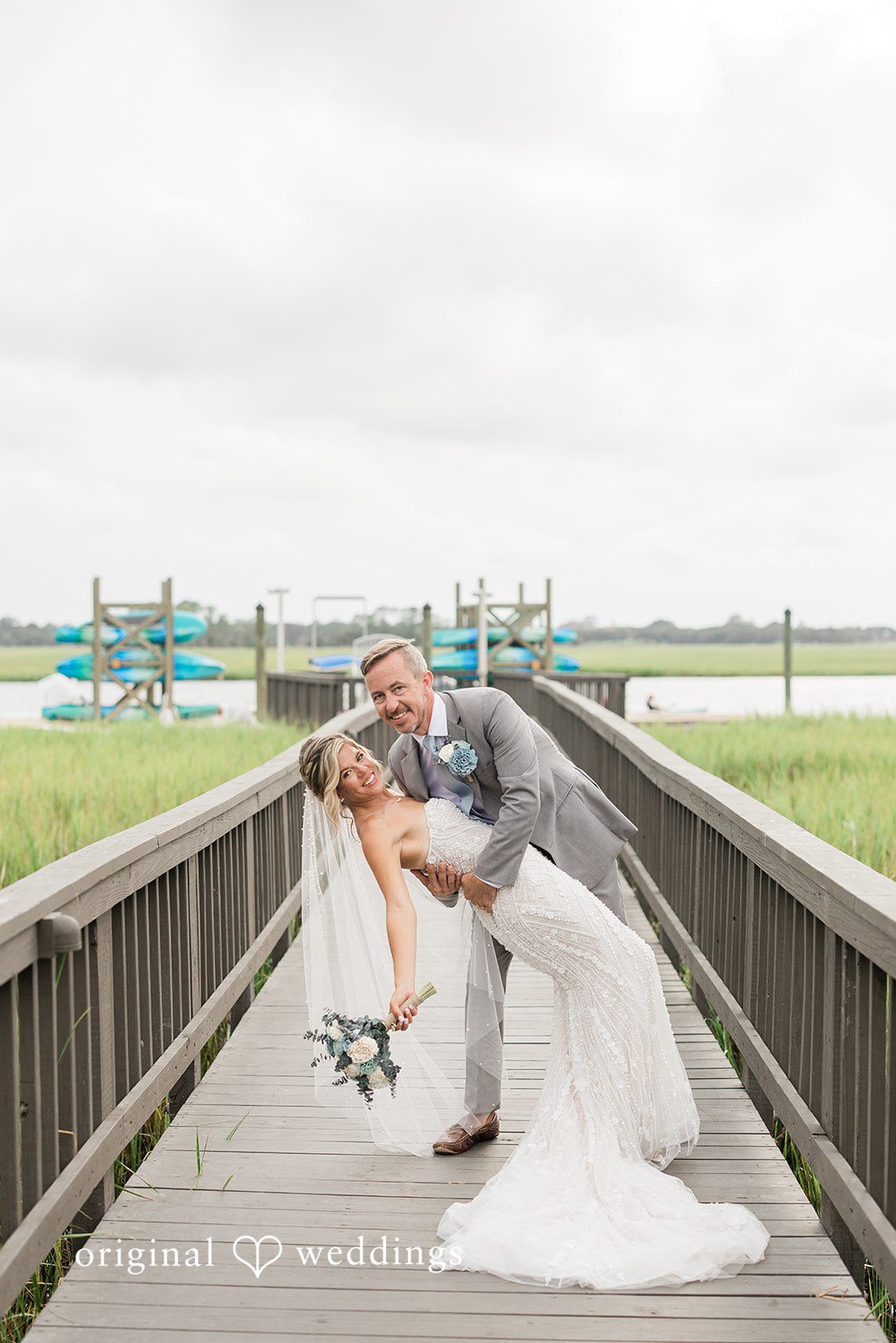 Jennifer + Zac A bride walking down a long wooden dock toward the groom.