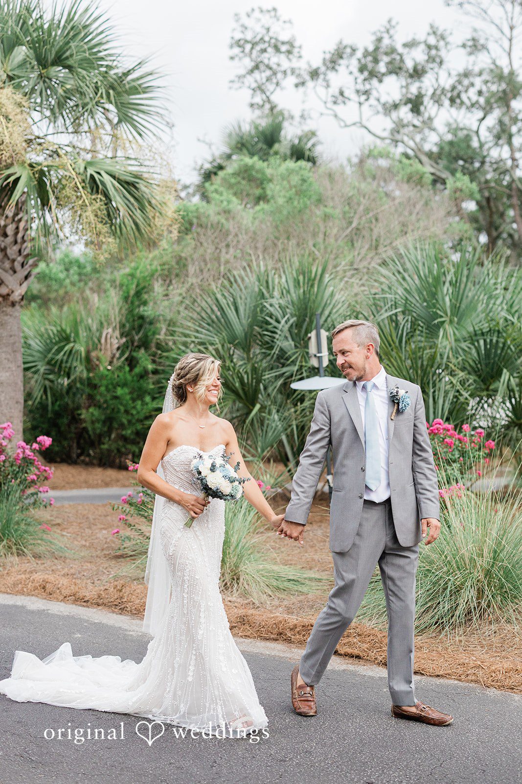 Jennifer + Zac A bride and groom walking together in a grassy area.