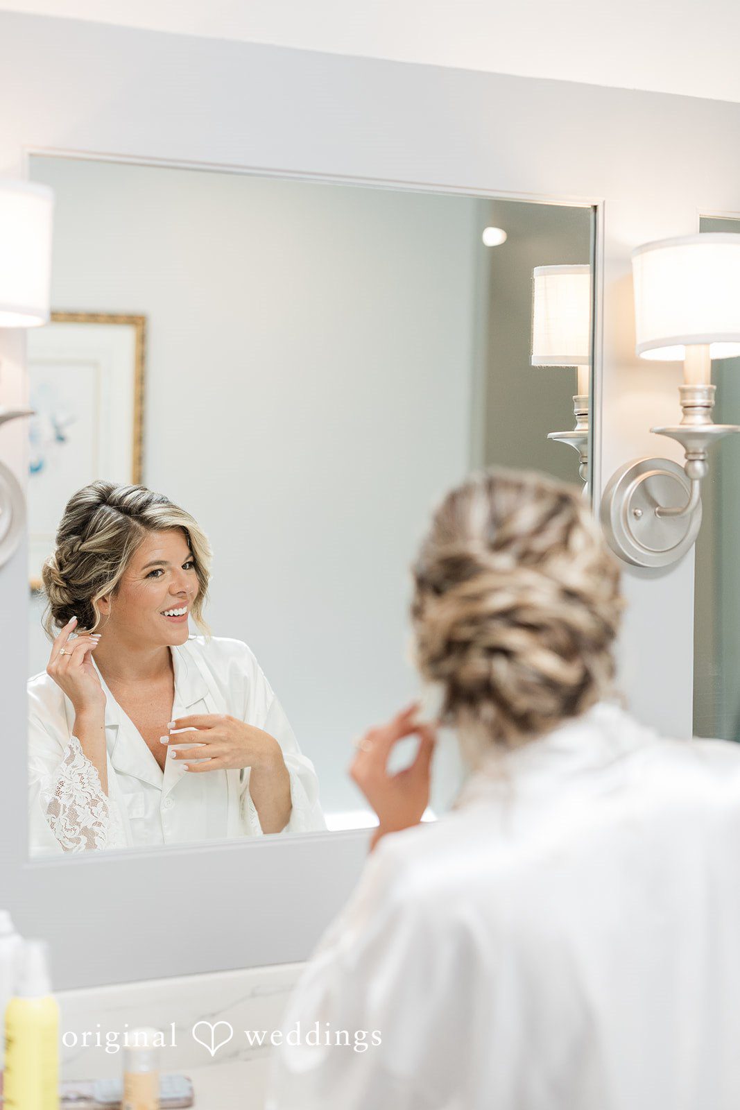 Jennifer + Zac A bride styling her hair in front of a mirror while getting ready for her wedding.