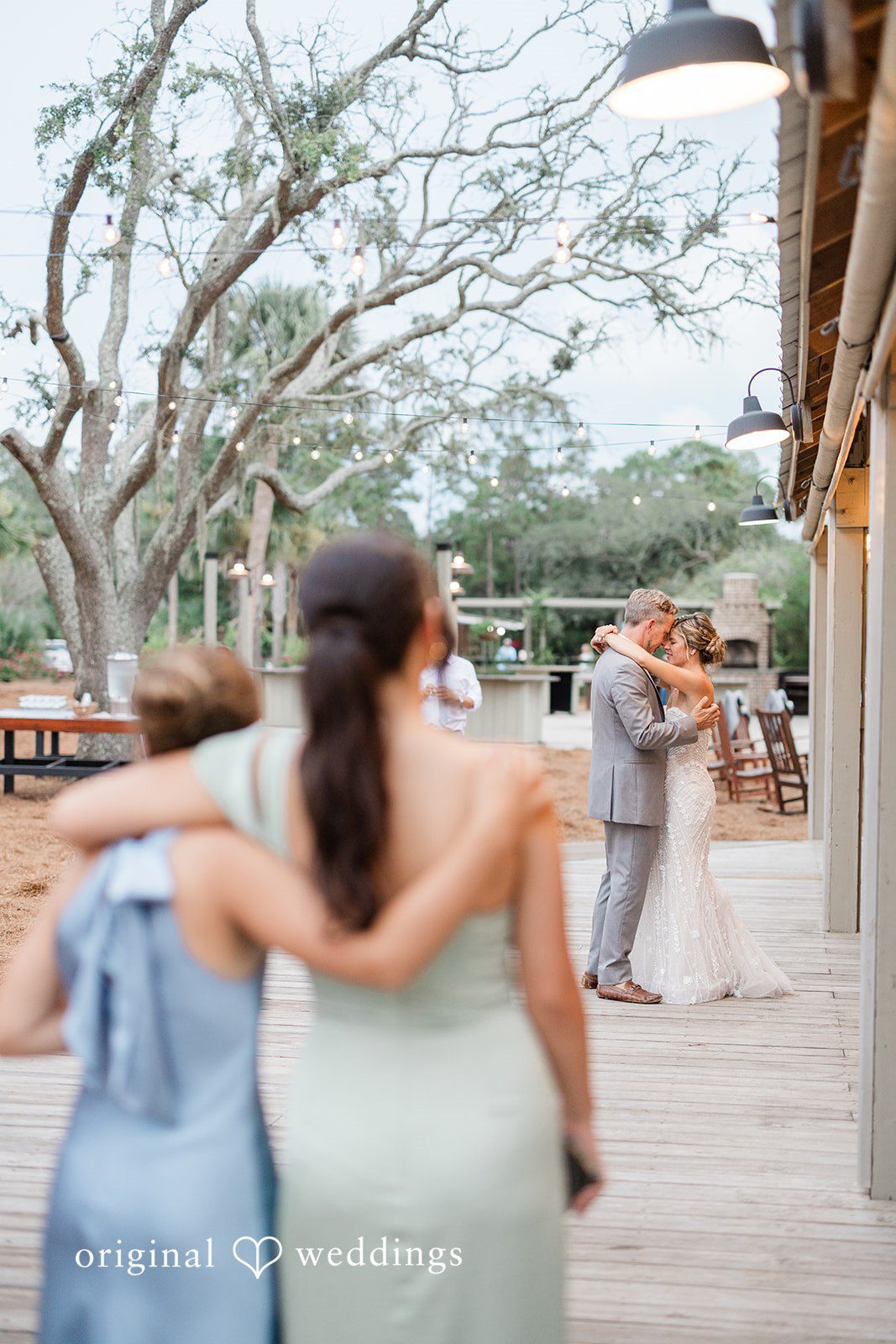 Jennifer + Zac A view from behind a bride as she walks toward a wedding reception area.