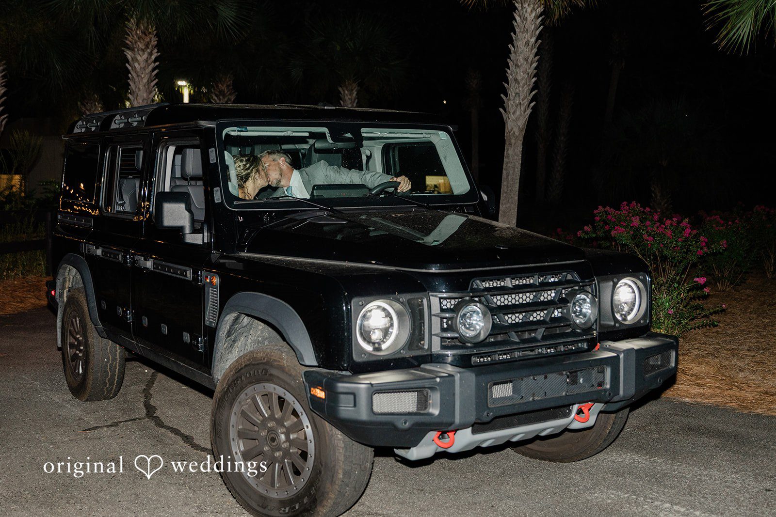 Jennifer + Zac A black off-road Jeep parked outside at night during a wedding exit.