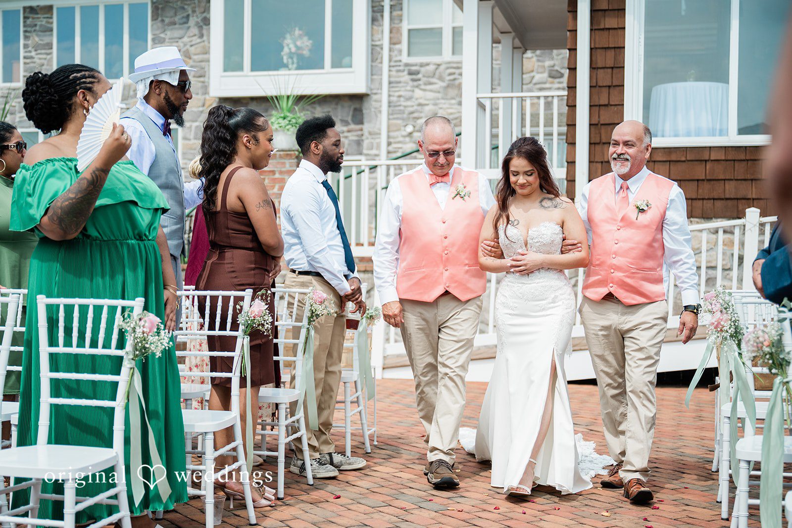 The bride's family escorts the bride down the aisle