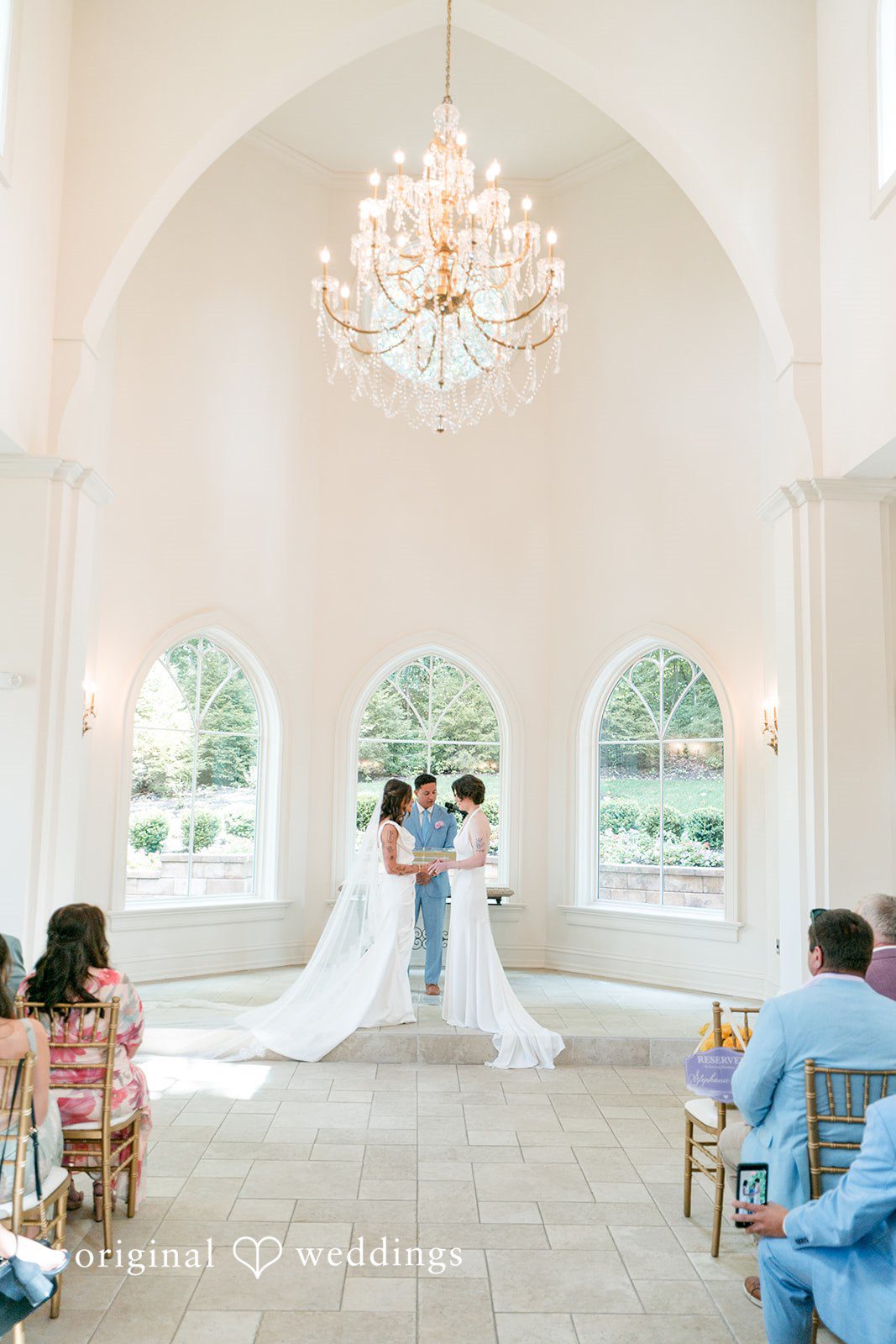 A wedding ceremony taking place at an altar under a high ceiling.
