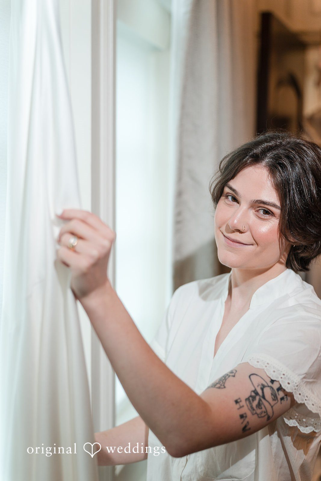 A bride smiling while getting ready before her wedding ceremony.