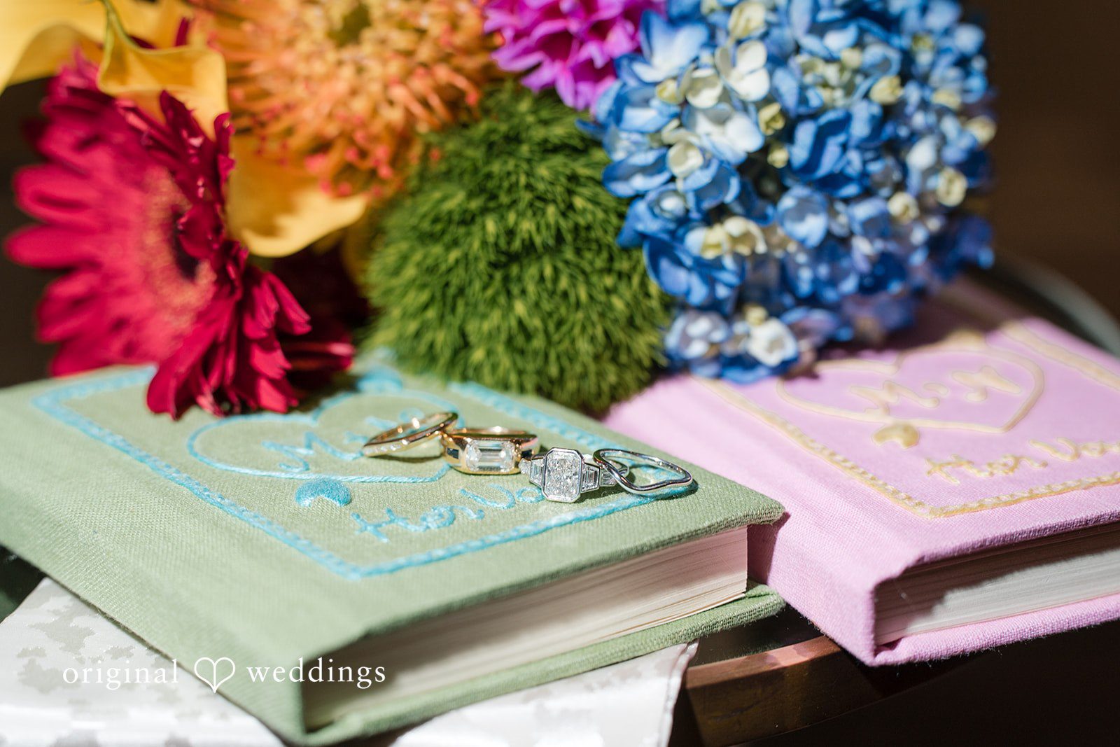 Close-up of colorful floral arrangements placed next to a decorated table setting.