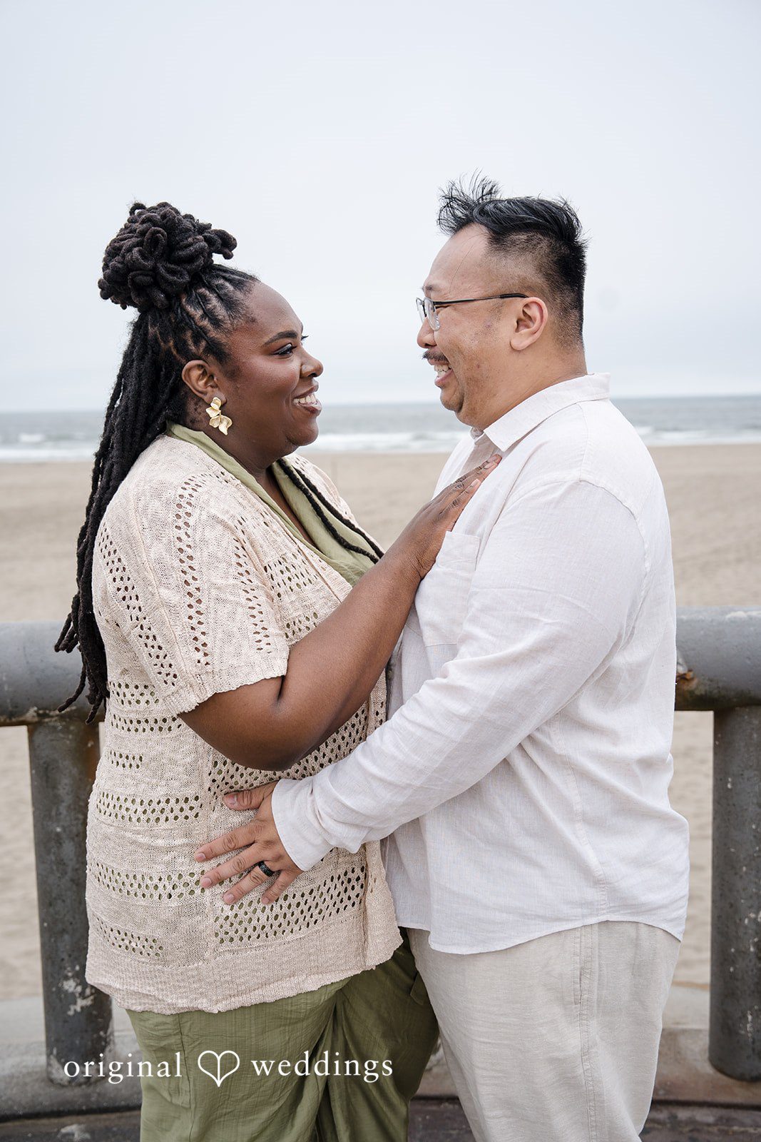 Ashley + Willard Couple face each other smiling and sharing a close moment on the beach.