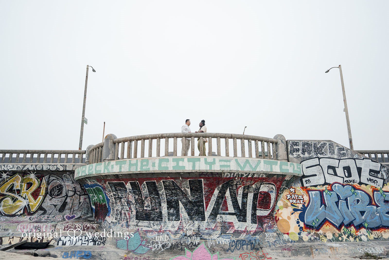 Ashley + Willard A view of a decorated concrete structure or boardwalk barrier set against an overcast sky.