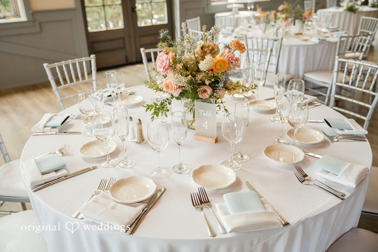 Daniel + Karen An overhead view of a round reception table beautifully set for guests with floral arrangements.