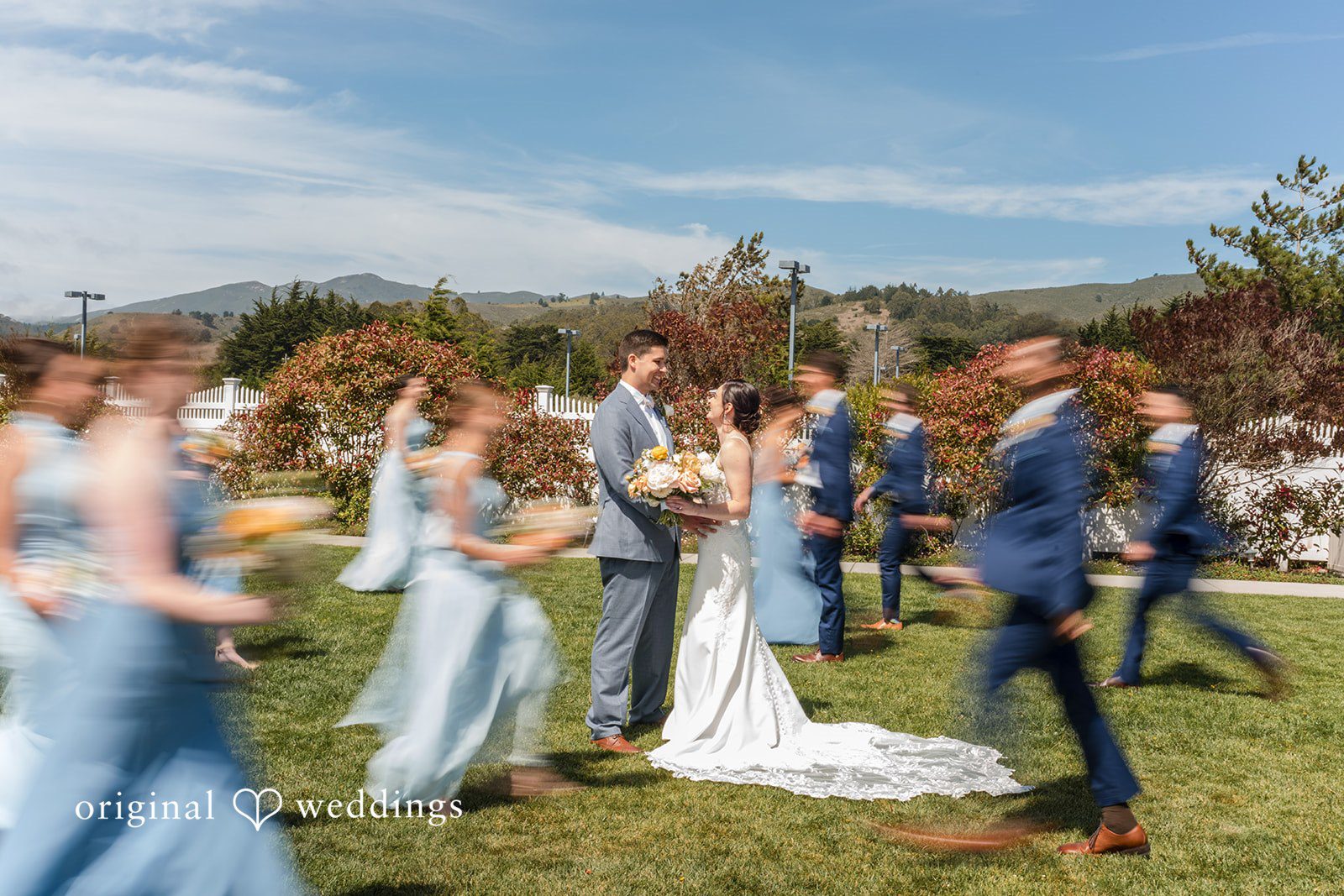 Daniel + Karen A bridal party celebrating and posing together on an open lawn.