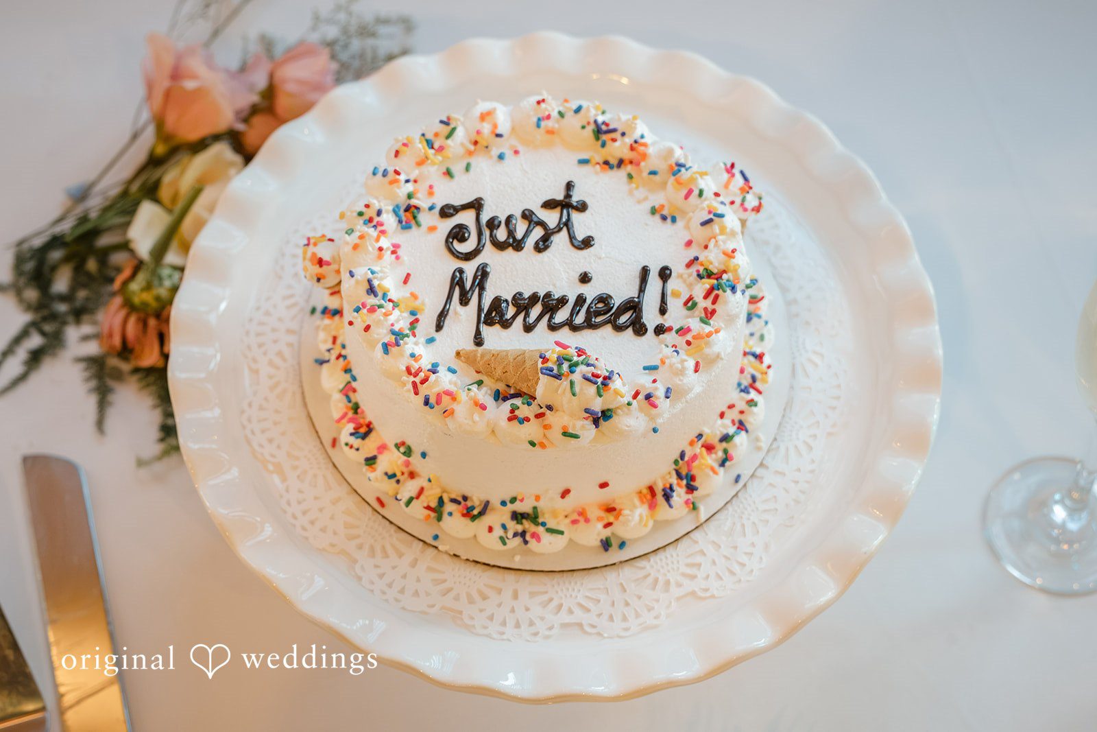 Daniel + Karen A decorated single-tier wedding cake with custom topper text presented on a white serving plate.