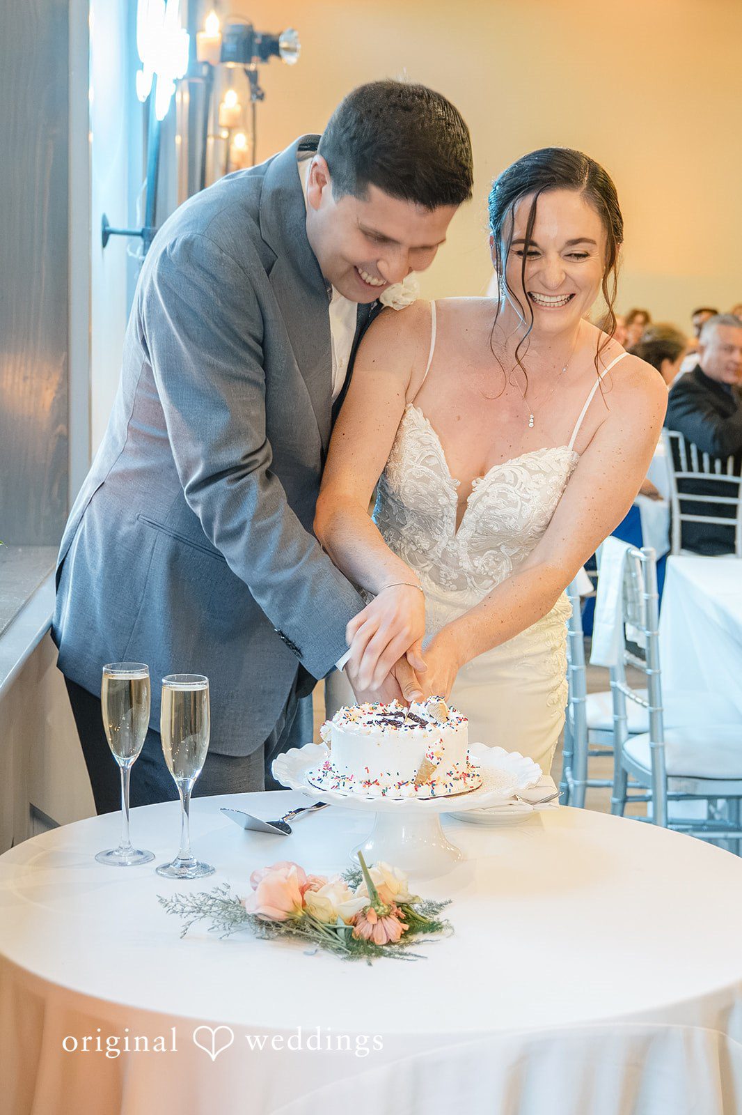 Daniel + Karen A bride and groom cutting their wedding cake at a reception table.