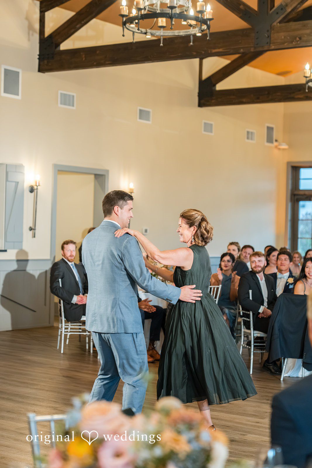 Daniel + Karen A groom in a grey suit shares a dance with a woman in a dark green dress.