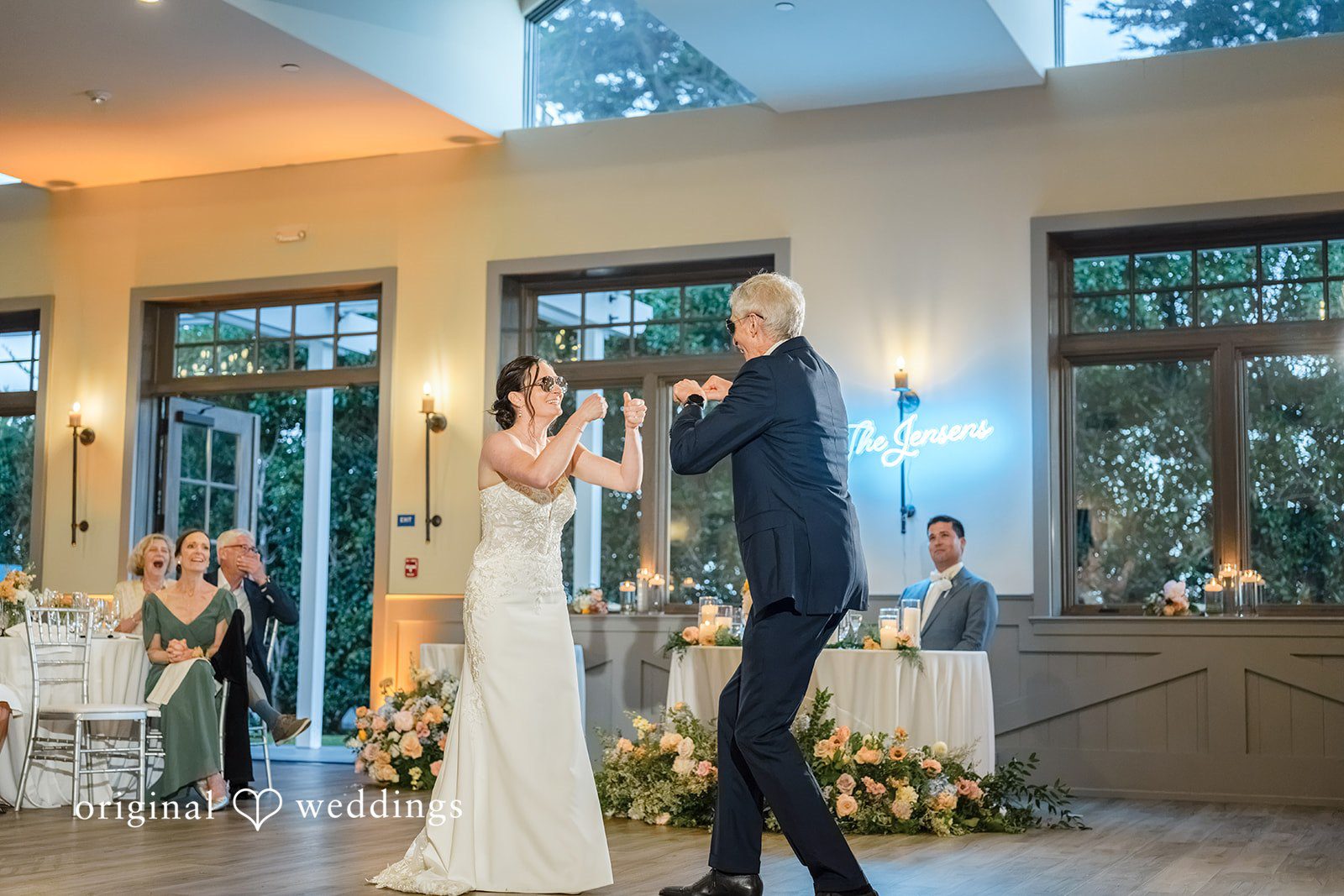 Daniel + Karen A bride and man dancing together near large glass venue doors.