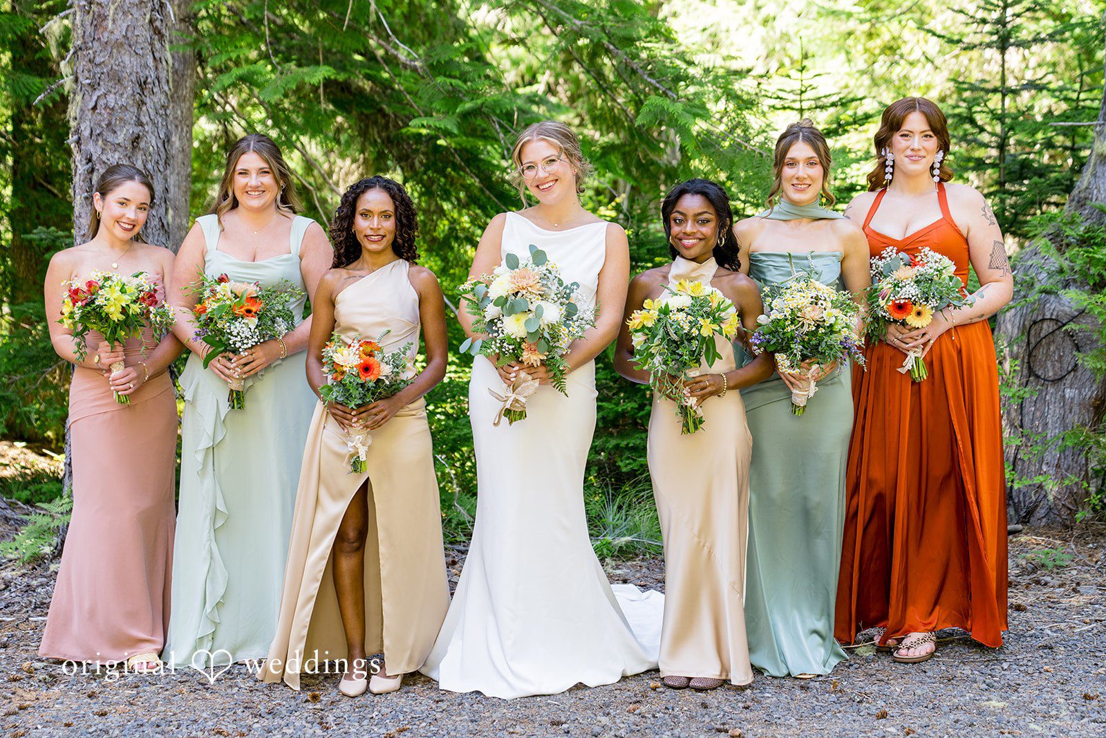 Abigail + Reece Bride and bridesmaids posing in coordinating earth-toned gowns.