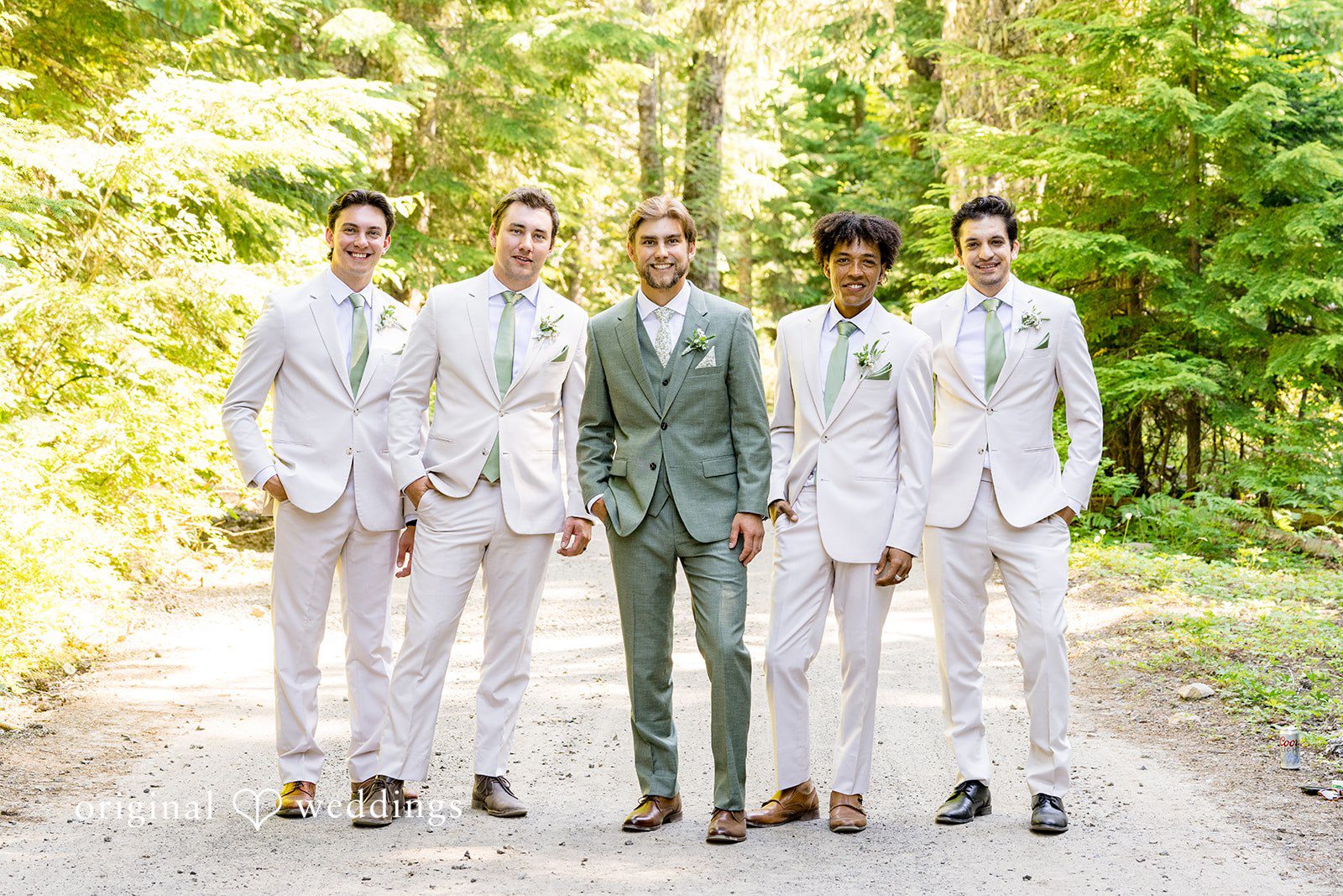 Abigail + Reece A groom posing with his groomsmen in light-colored suits.