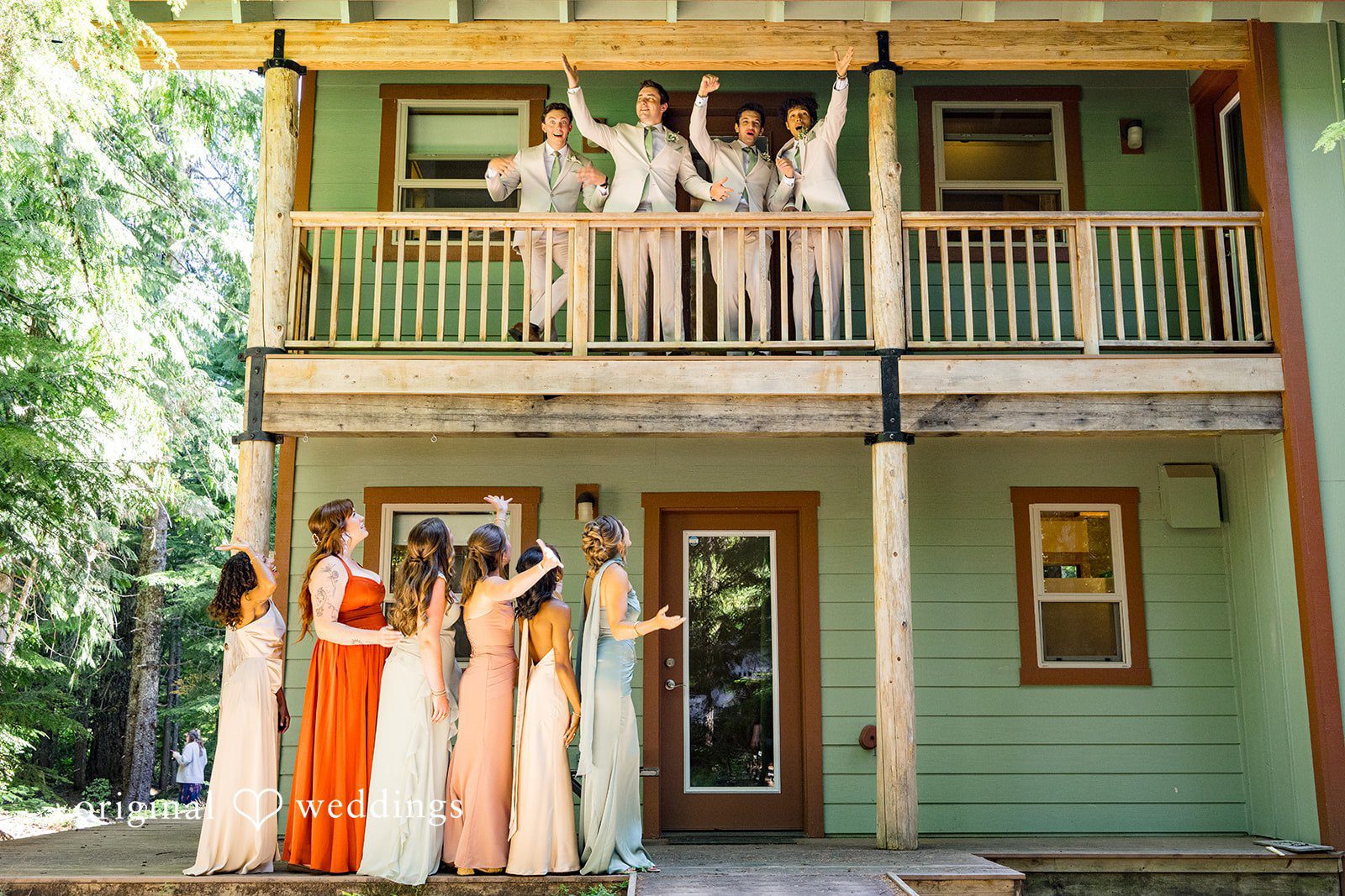 Abigail + Reece Bridesmaids waving from a balcony and the ground of a green building.