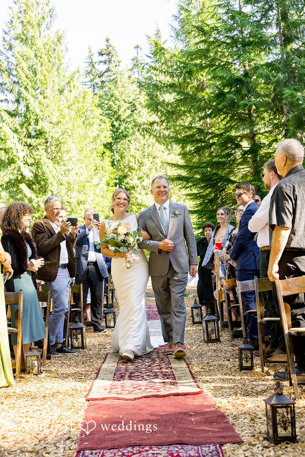 Abigail + Reece A wedding ceremony setting with guests seated in a wooded area.