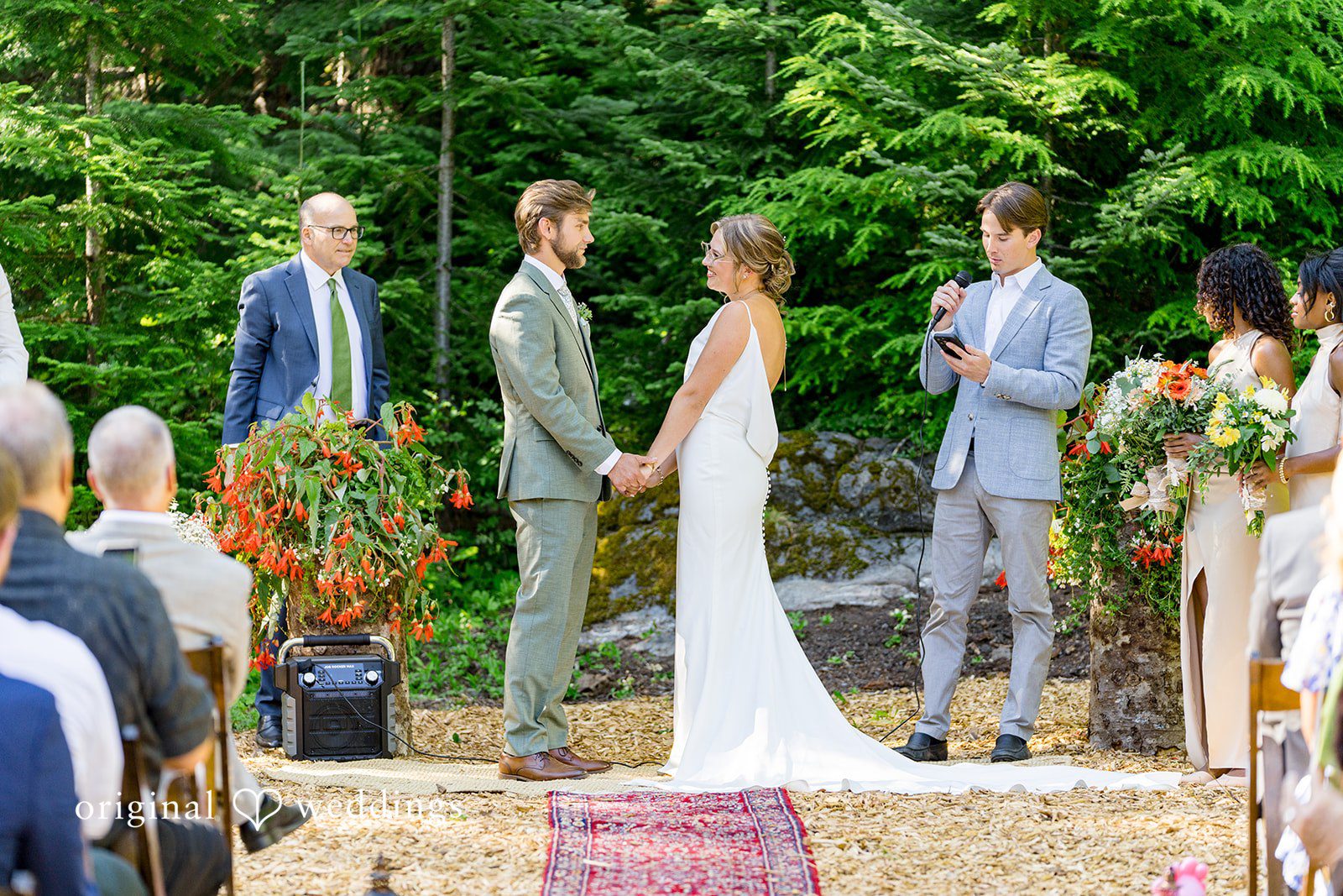 Abigail + Reece A wedding ceremony taking place at an altar surrounded by trees.