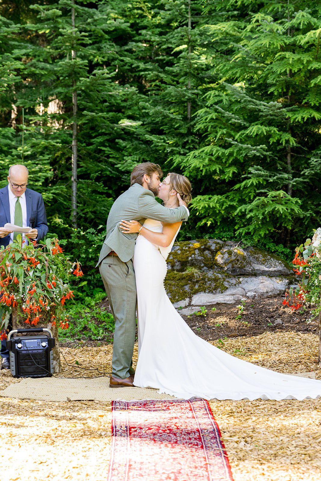 Abigail + Reece A bride and groom sharing a kiss at the end of the aisle.