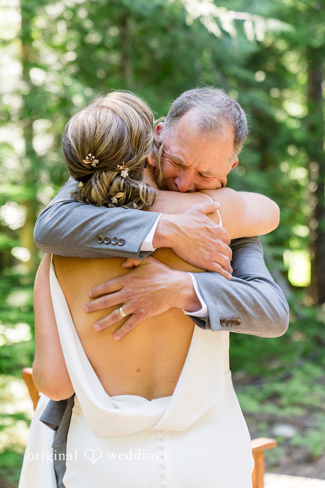 Abigail + Reece A bride in a white gown sharing an emotional embrace with a man in a gray suit.