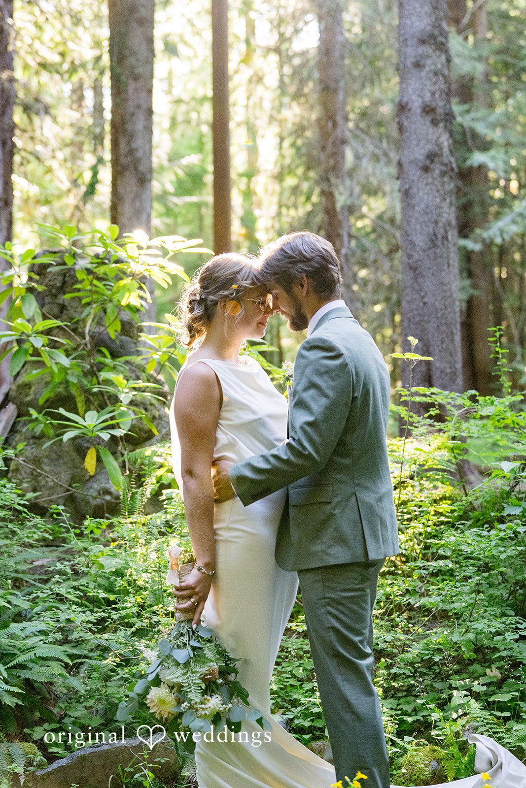 Abigail + Reece A bride and groom hugging closely in a forest setting.
