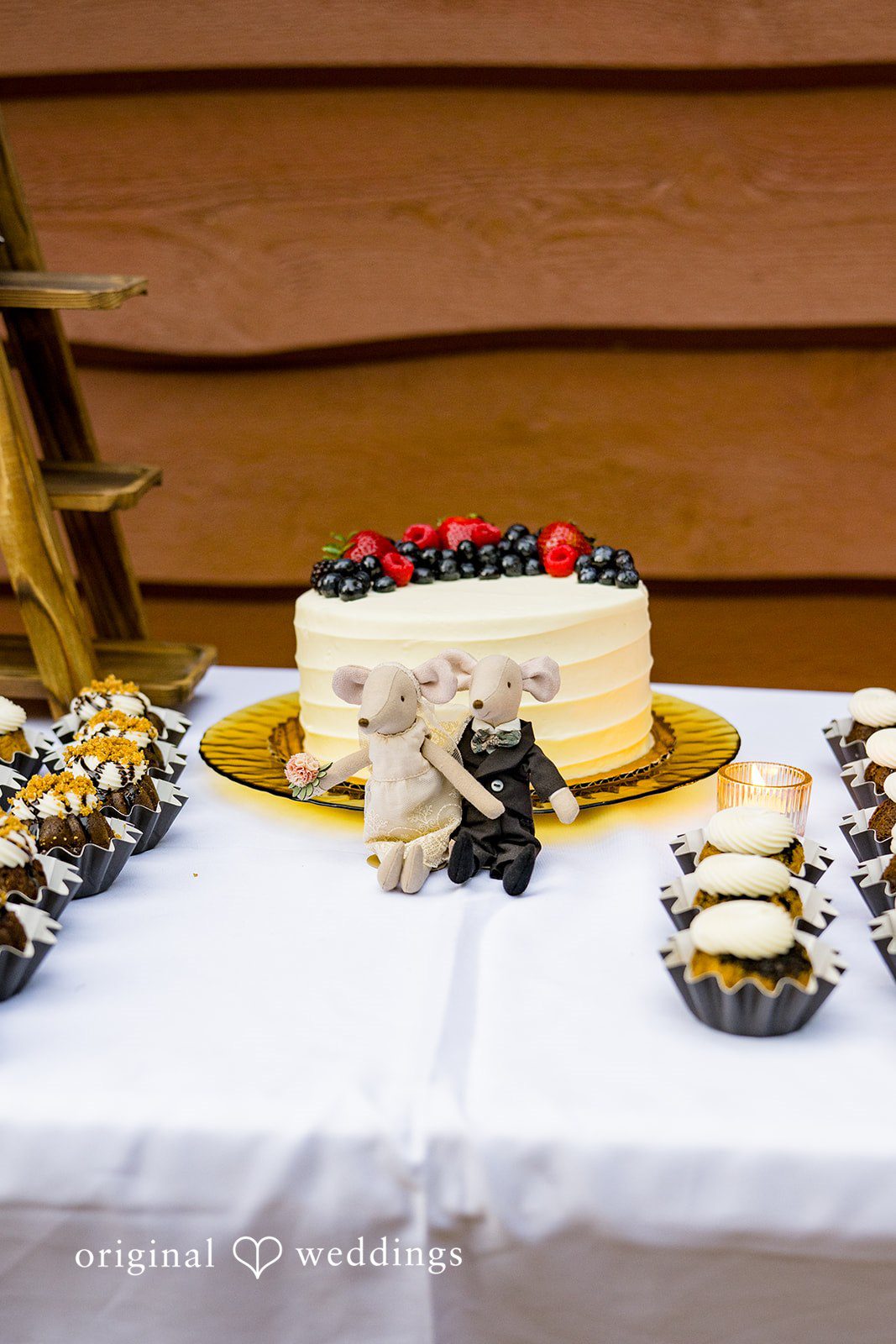 Abigail + Reece A wedding cake displayed on a table with desserts.