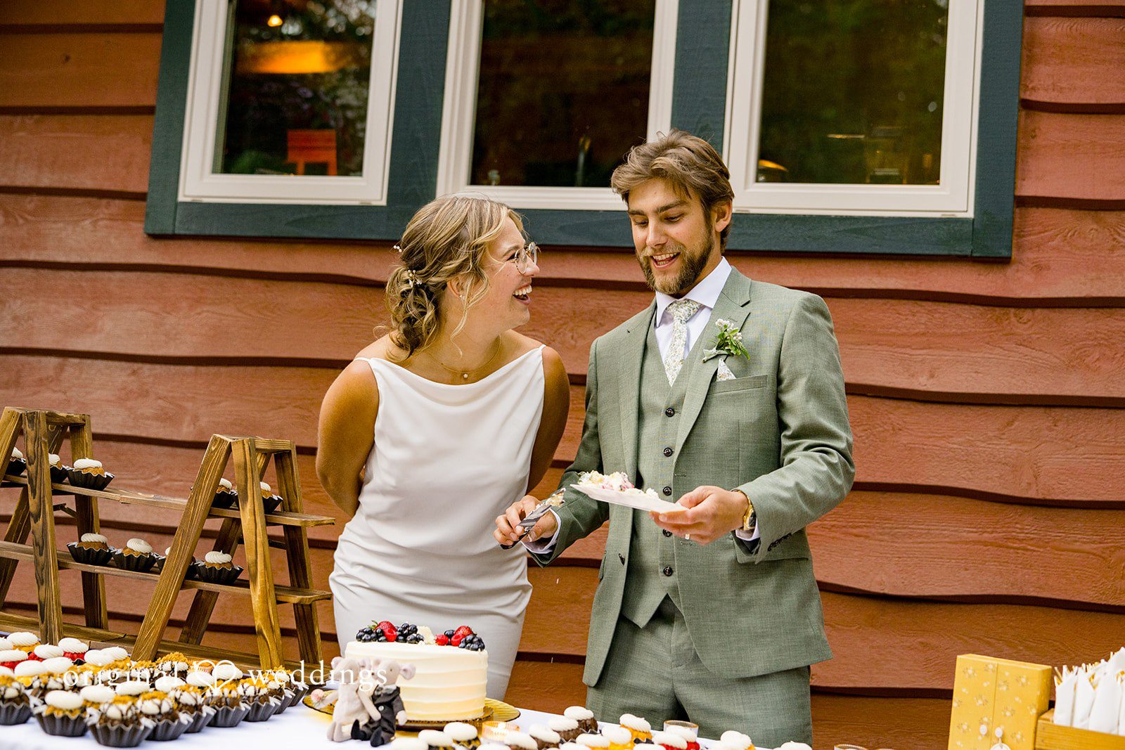 Abigail + Reece A bride and groom standing next to a food display table.
