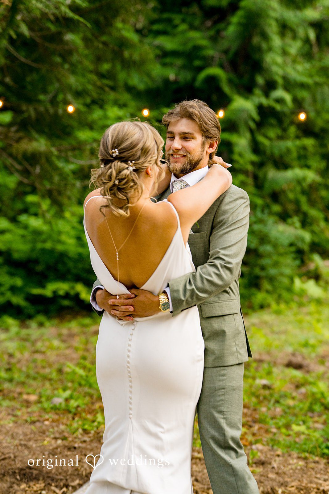 Abigail + Reece A bride and groom embracing in a wooded clearing.