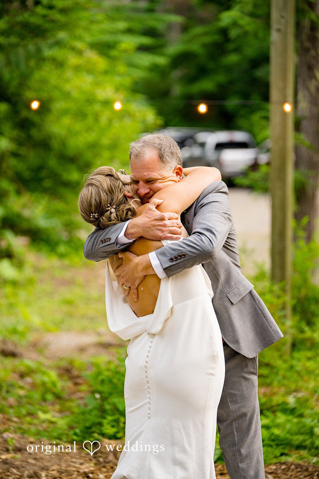 Abigail + Reece A bride in a white gown sharing an emotional embrace with a man in a gray suit.