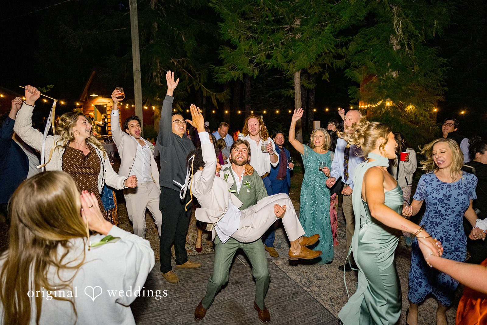 Abigail + Reece A crowded dance floor of guests celebrating under string lights.