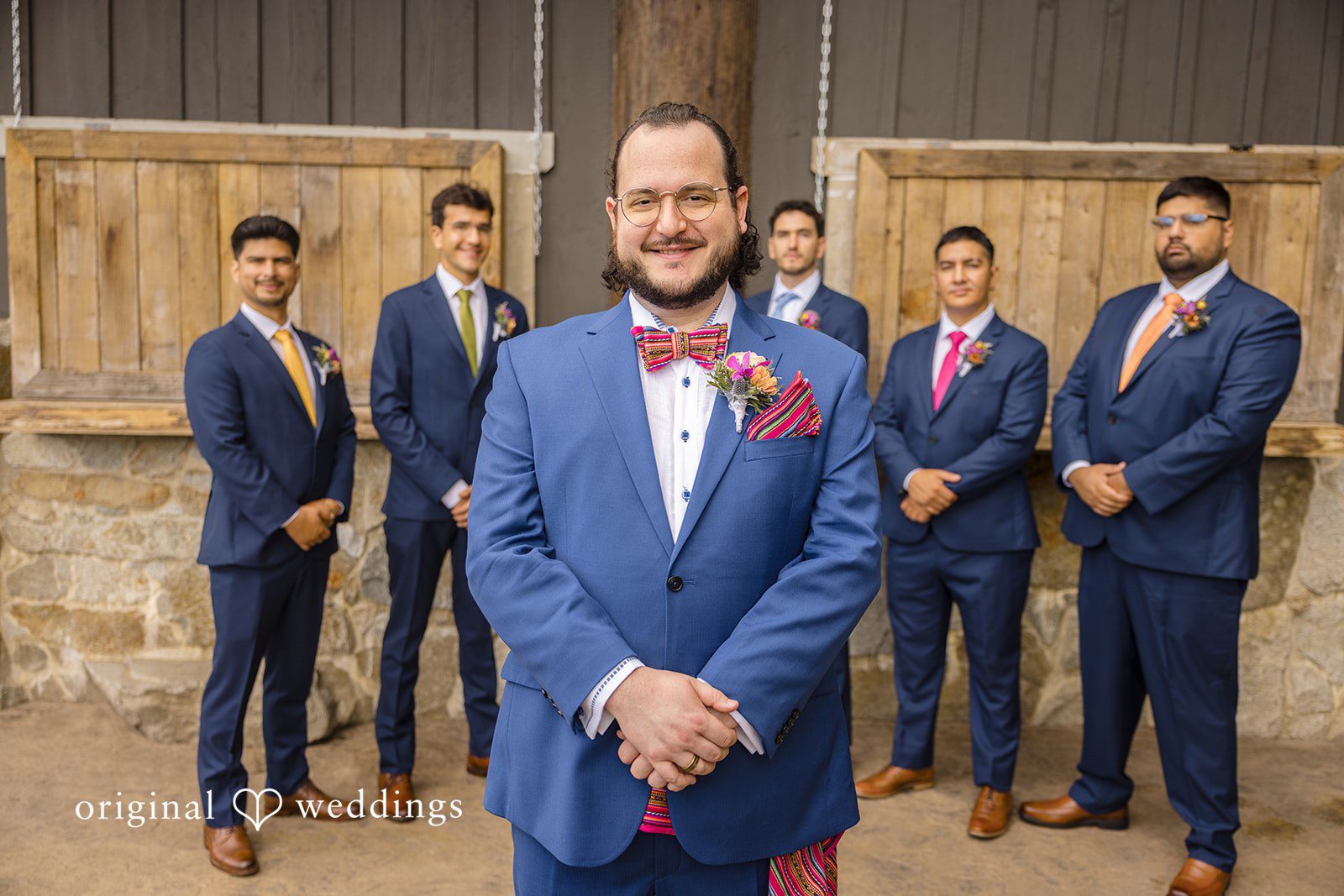 Diego + Adel A lineup of five groomsmen in blue suits standing together outside.