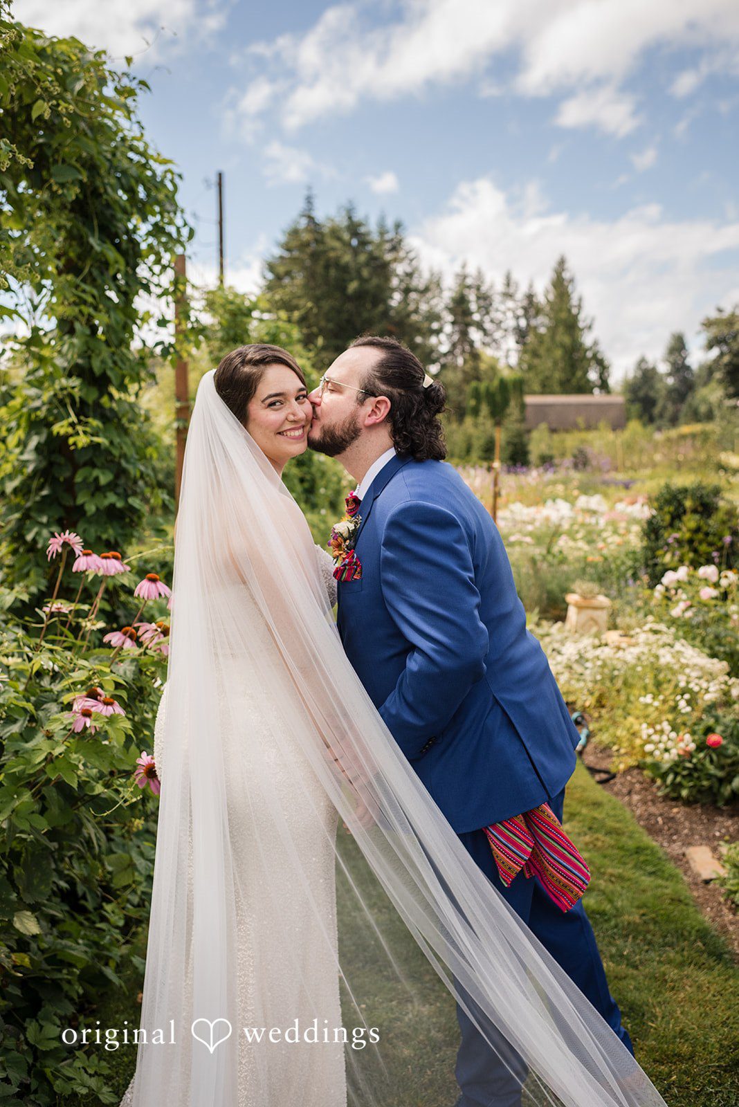 Diego + Adel A bride and groom sharing a passionate embrace in a grassy meadow.