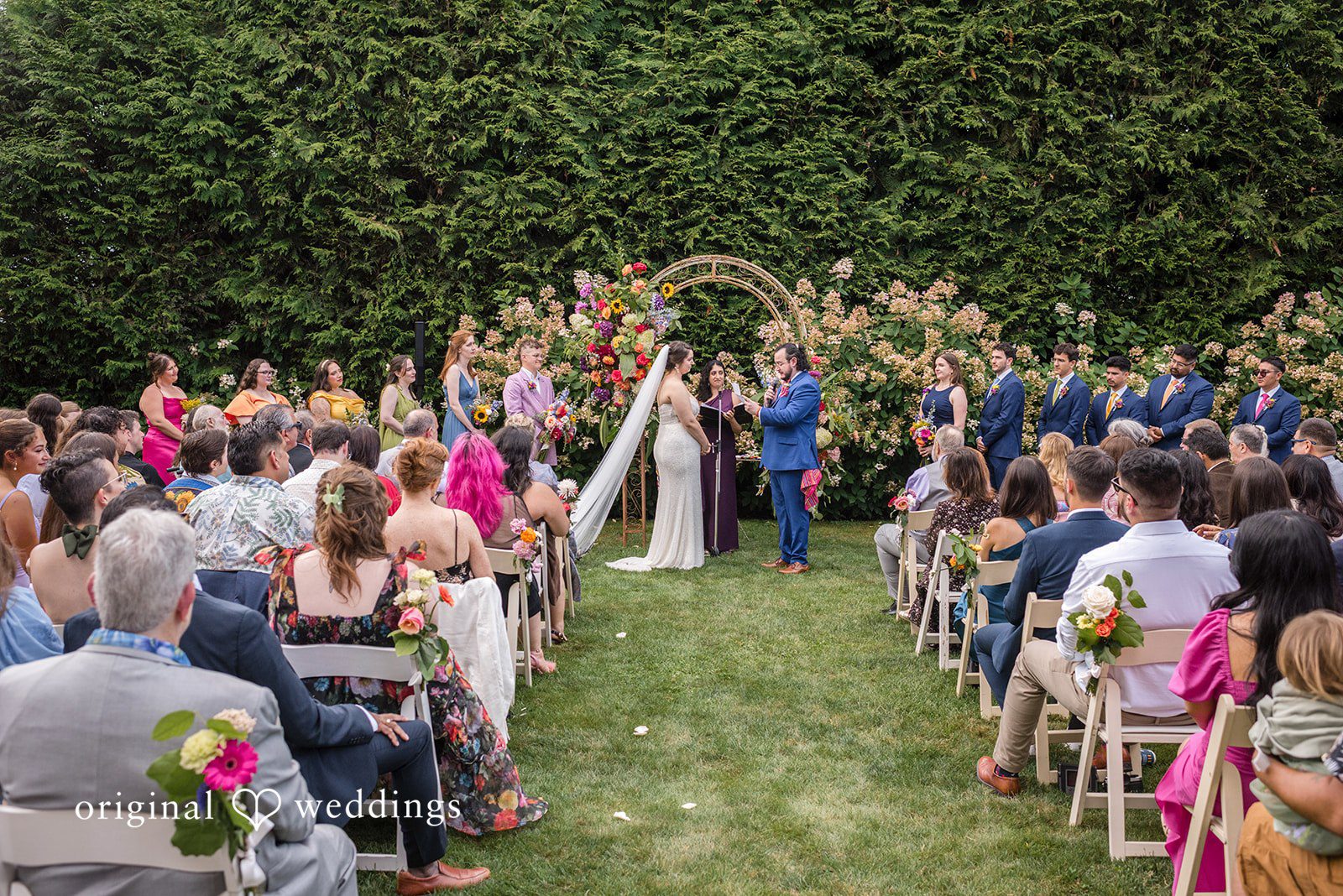 Diego + Adel An elevated view of a wedding aisle lined with seated guests during a ceremony.