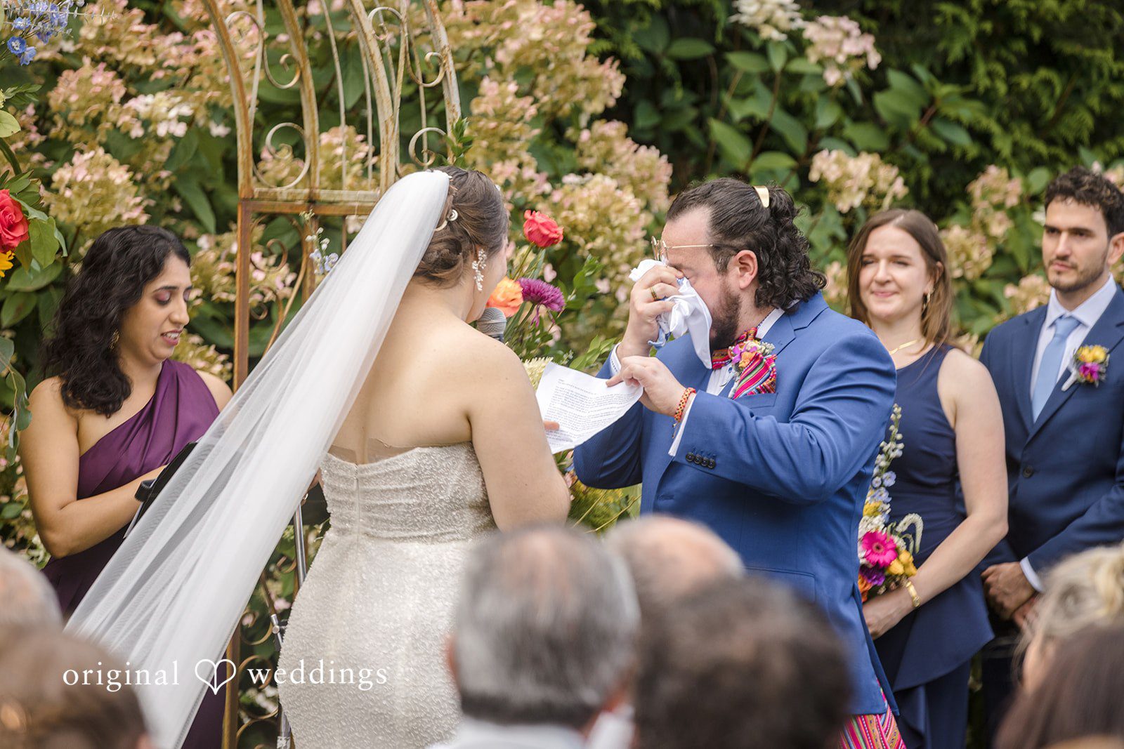 Diego + Adel An emotional groom in a bright blue suit wipes away tears with a tissue while his bride reads her wedding vows.