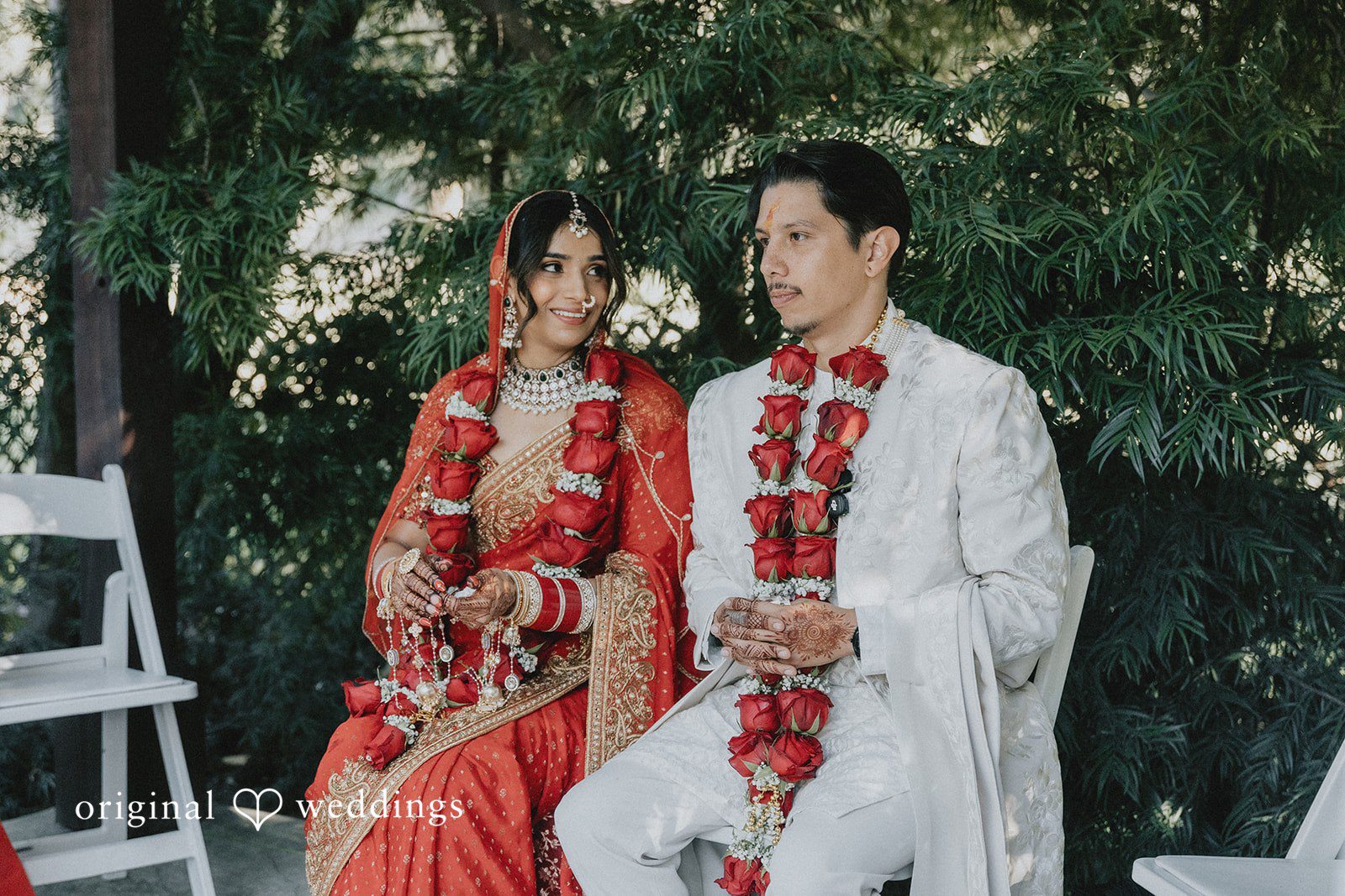 A bride and groom sitting side-by-side during their wedding ceremony.