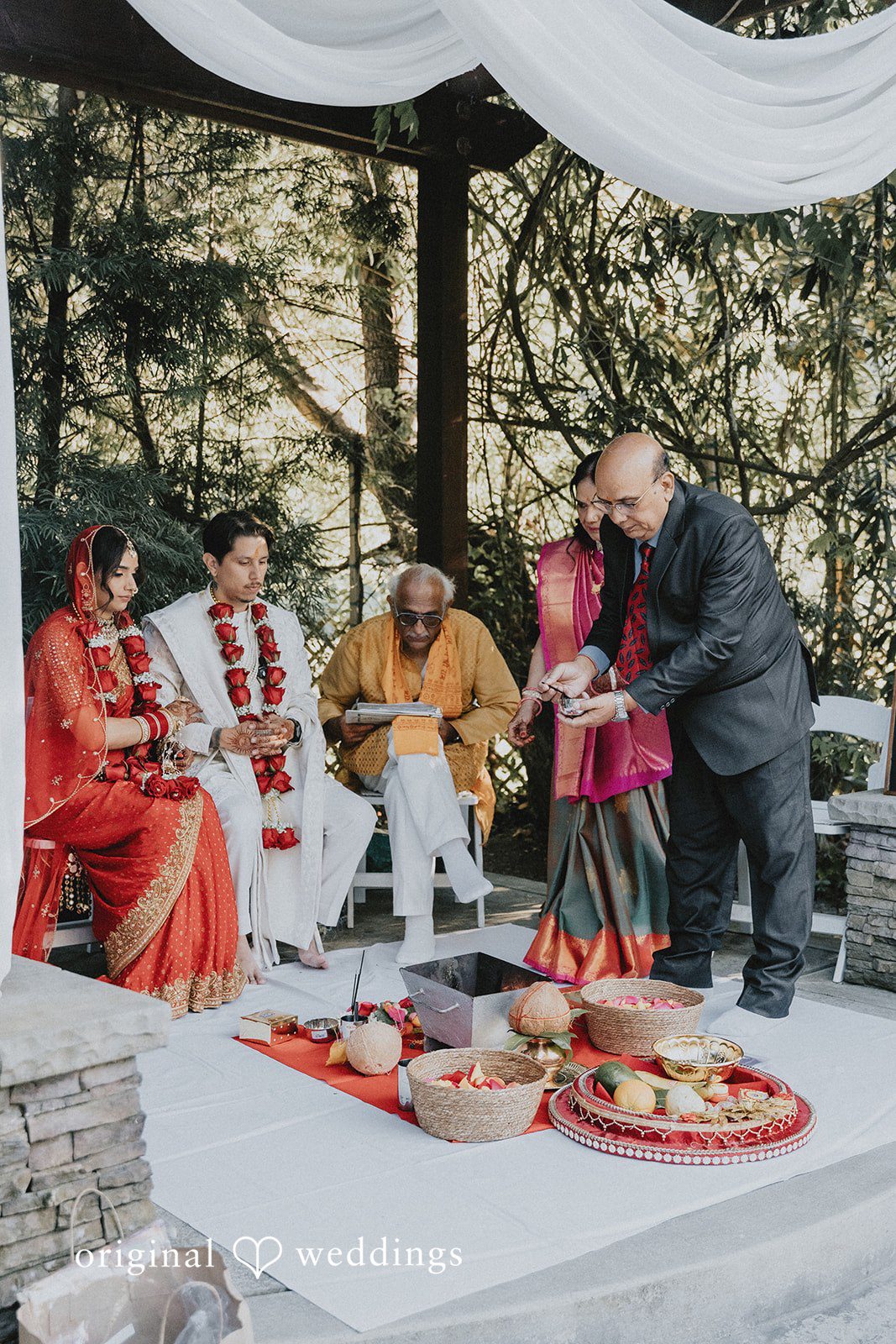 An elevated view of guests participating in a traditional ceremony on a rug.