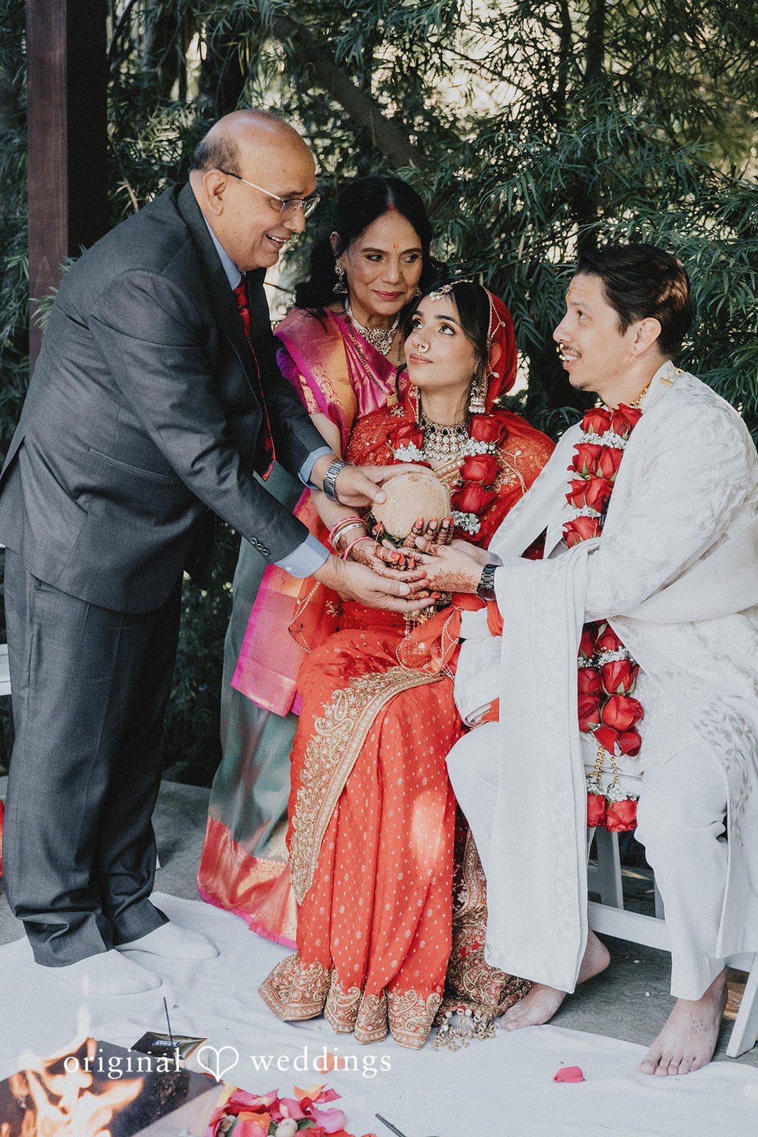 A family group smiling together in traditional wedding attire.