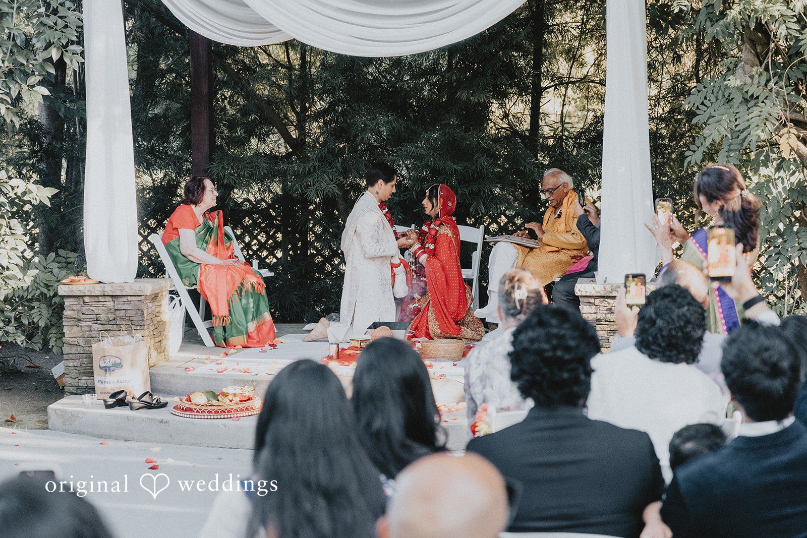 Guests seated on the chair watching a wedding ceremony.