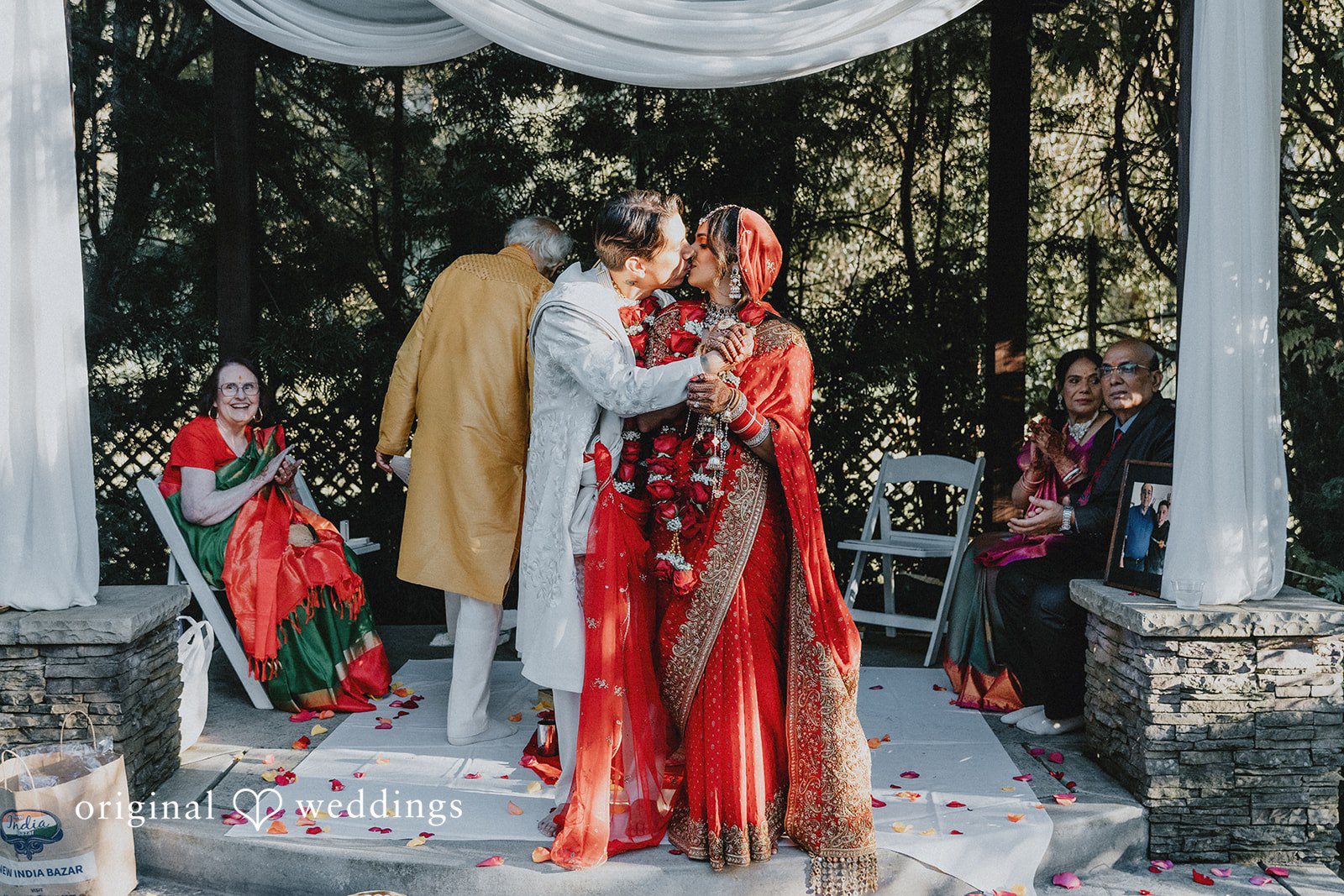 A bride and groom standing together beneath a decorated arch.