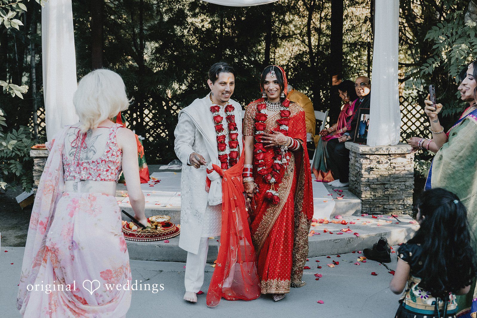 A bride and groom interacting with guests during their wedding.