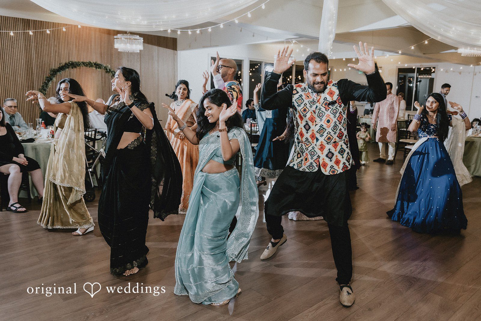 Wedding guests dancing and celebrating together on a crowded dance floor.