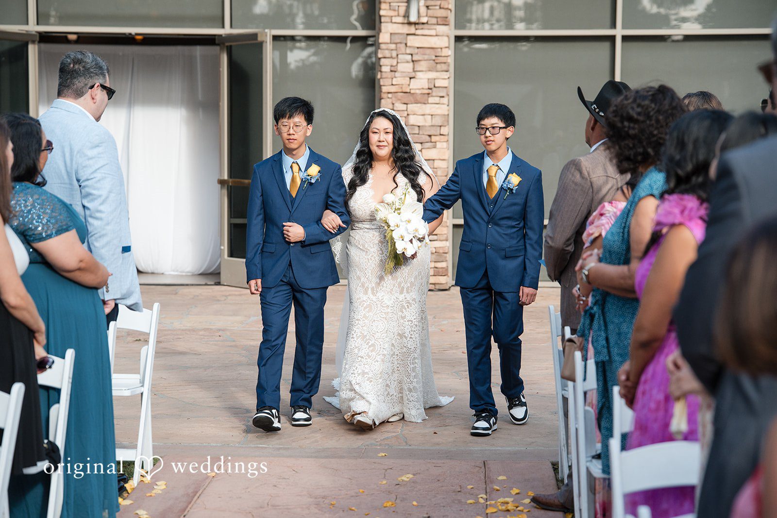 A wedding party walking down an aisle during a ceremony.