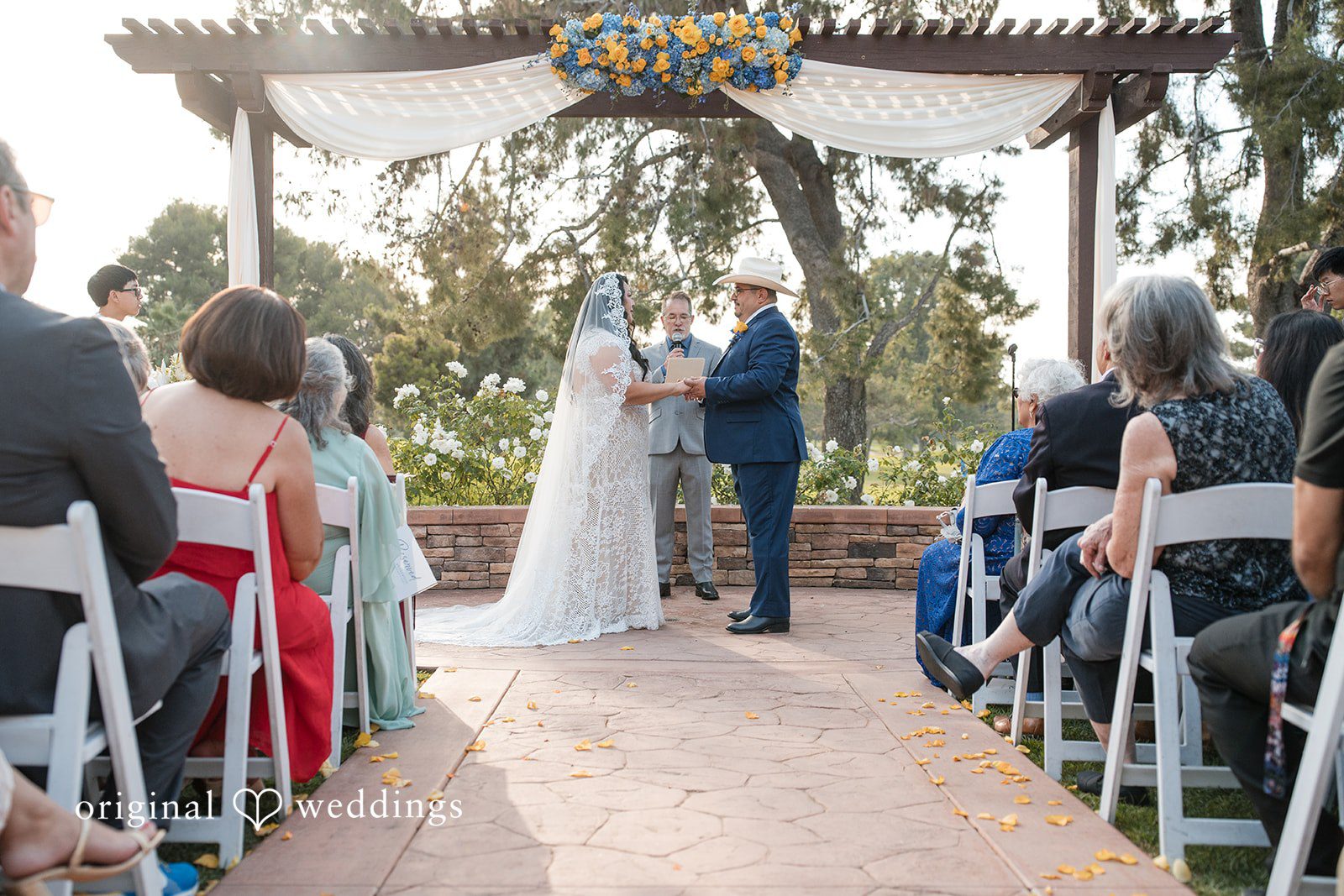 A wide view of a wedding ceremony with guests seated in rows.